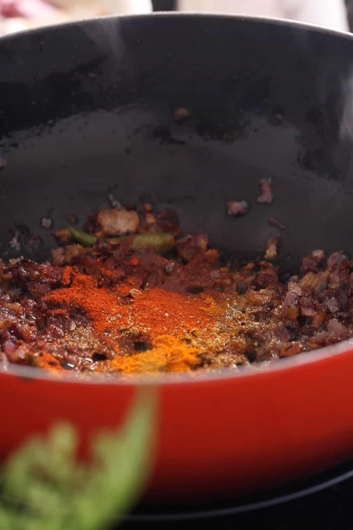 Spice powders are added to browned onions.