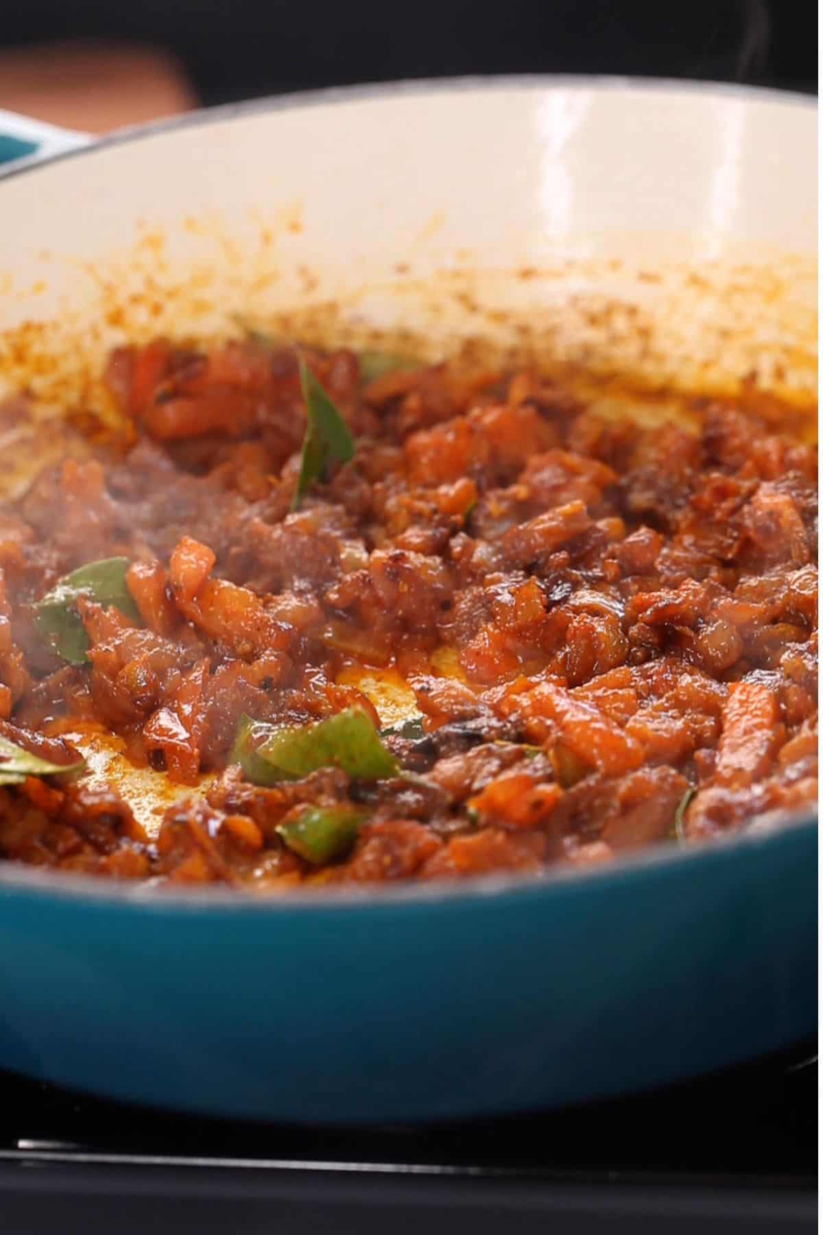 Peppery masala is cooked until tomatoes soften.