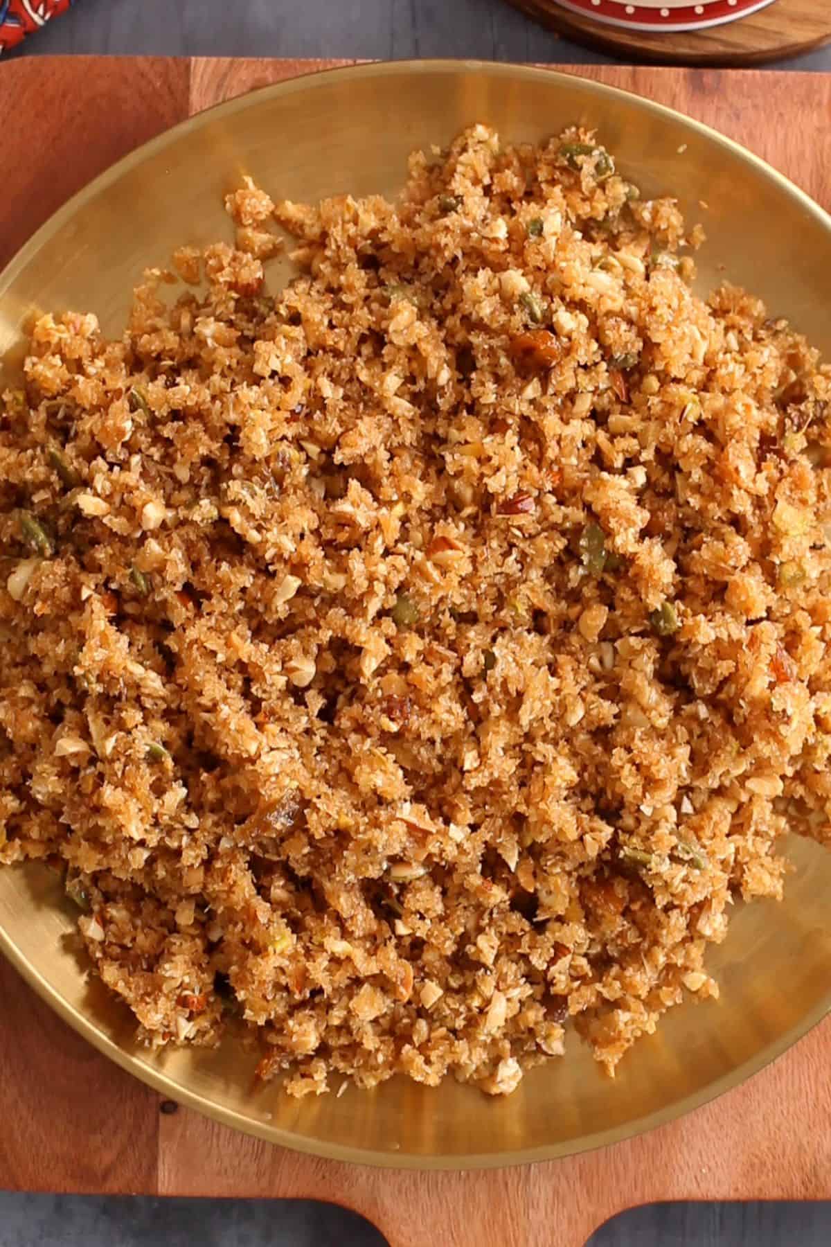 Coconut ladoo mixture is transferred to a plate to cool down.