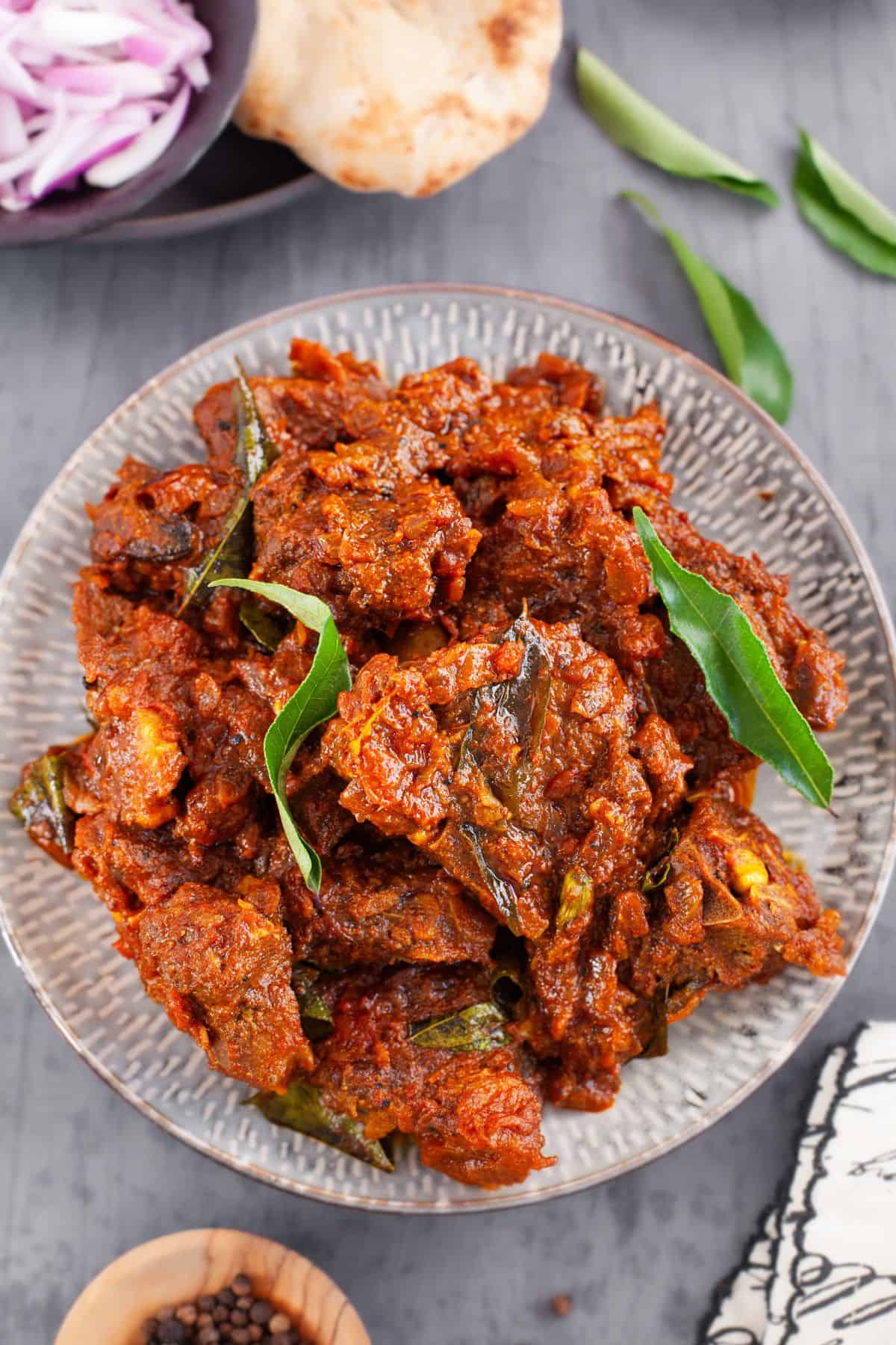 Overhead image of mutton fry in a grey background.
