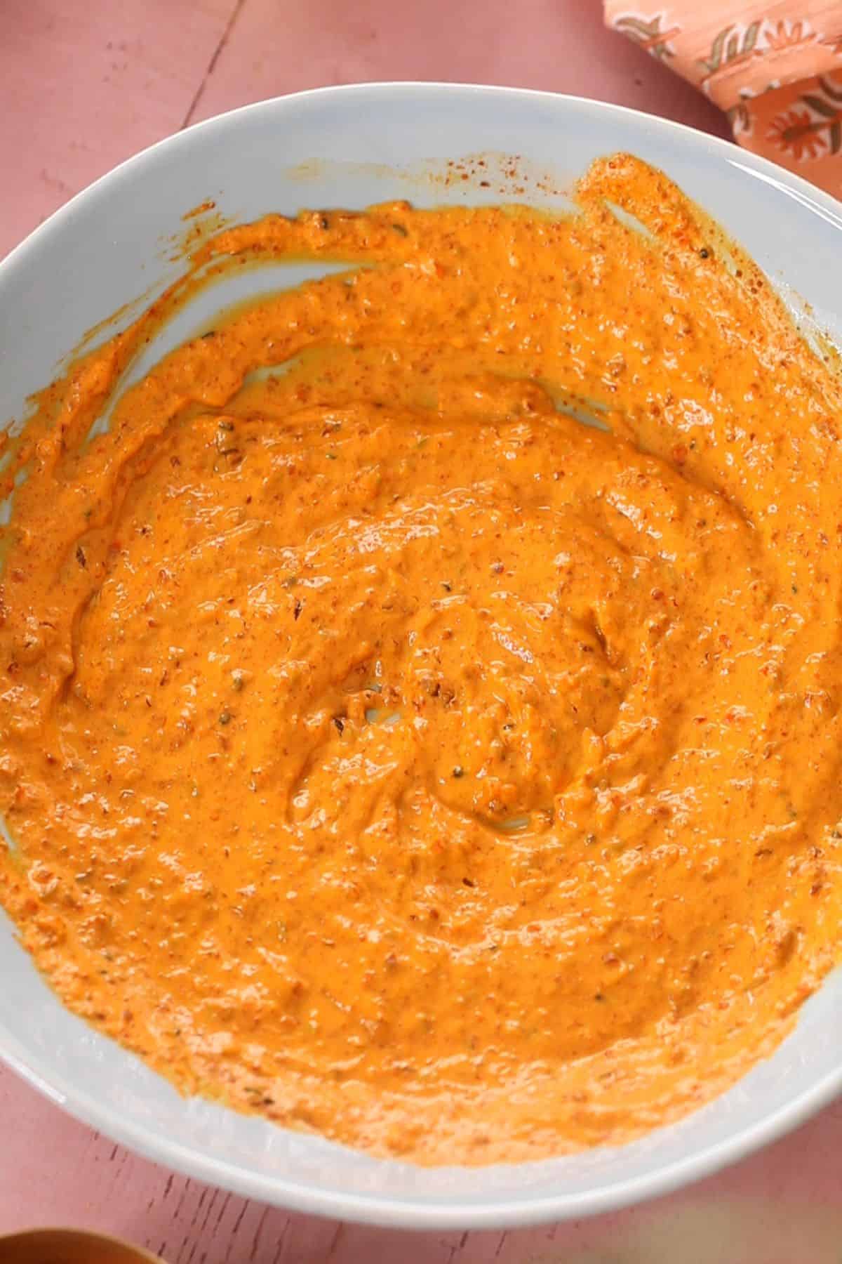 Achari marinade is ready in a large blue bowl.