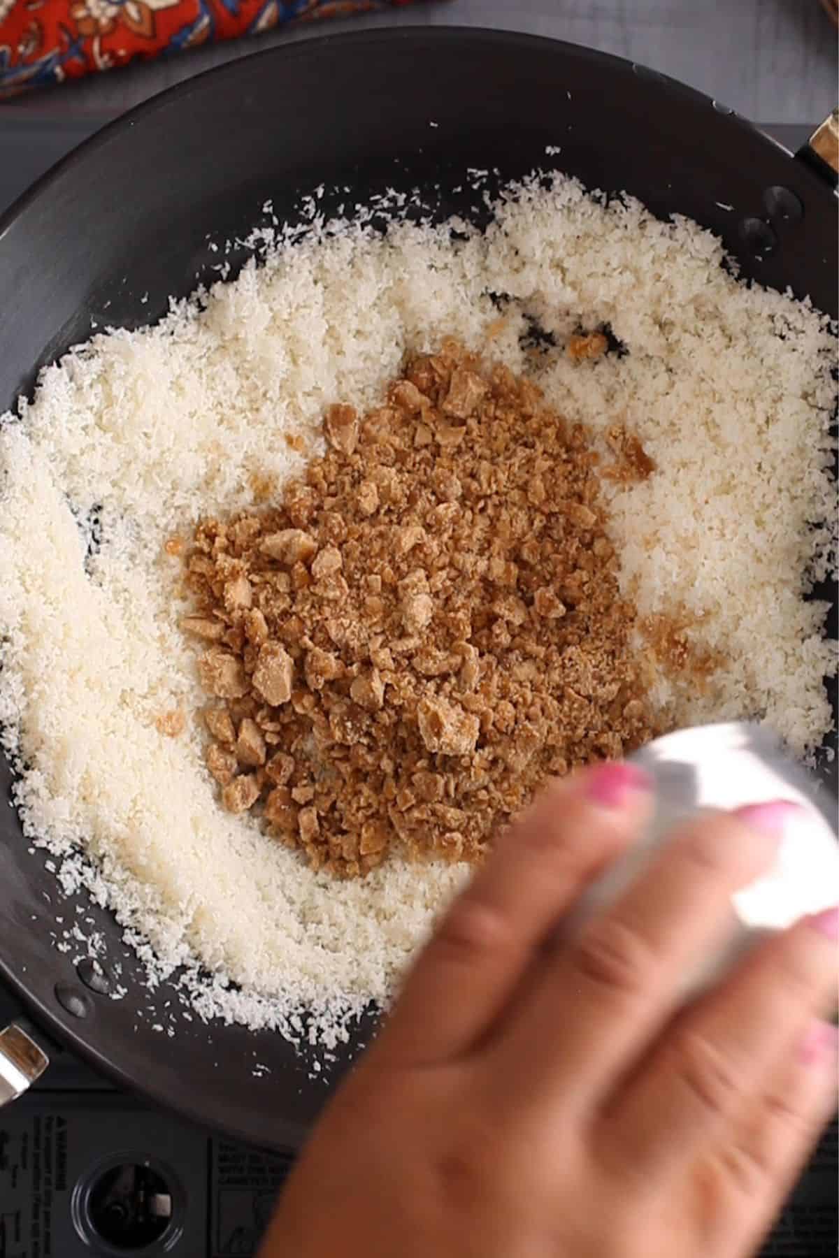 Chopped jaggery is added to toasted coconut.