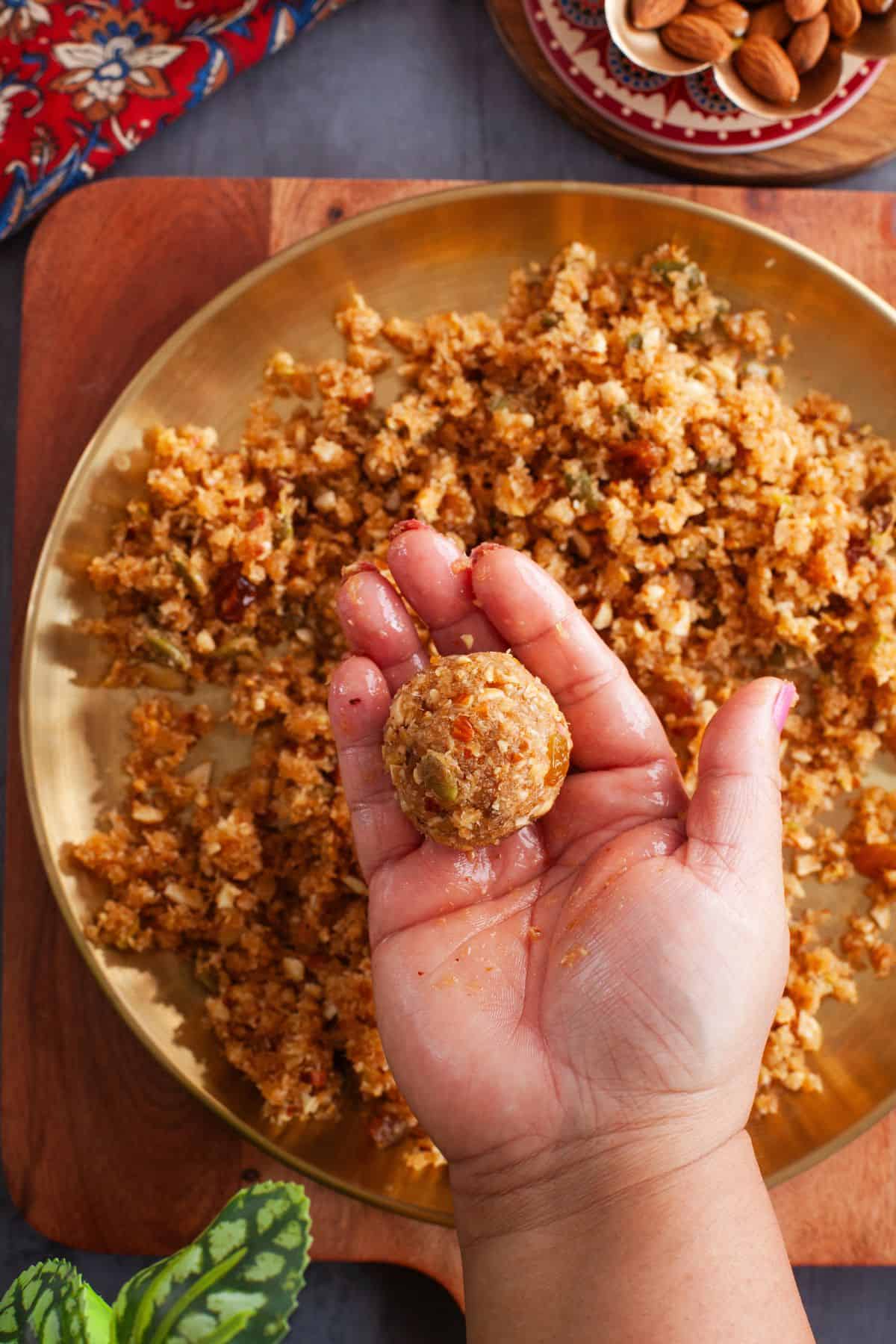 A shaped Coconut Ladoo in hand.
