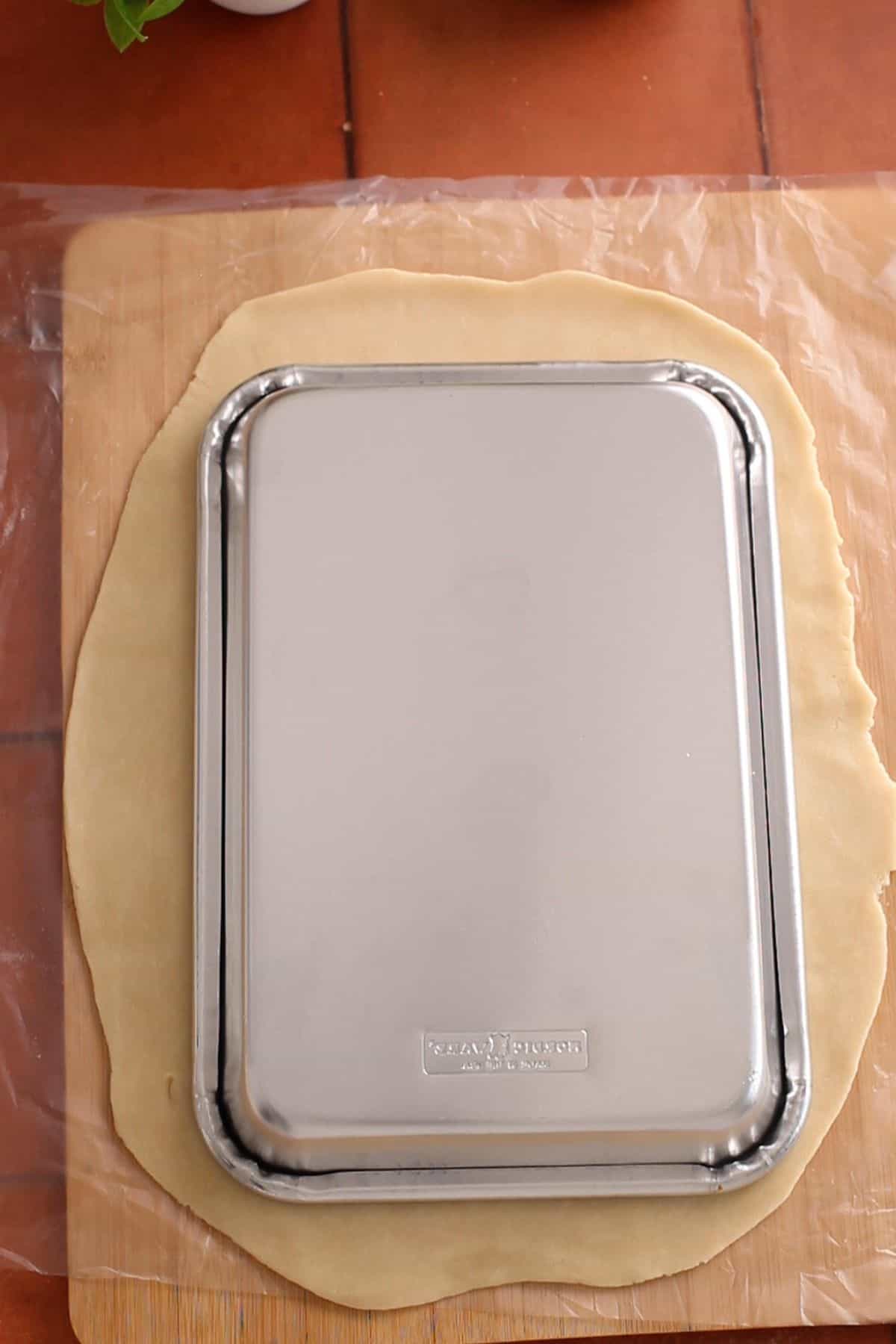 Cutting pie crust into a rectangular shape.