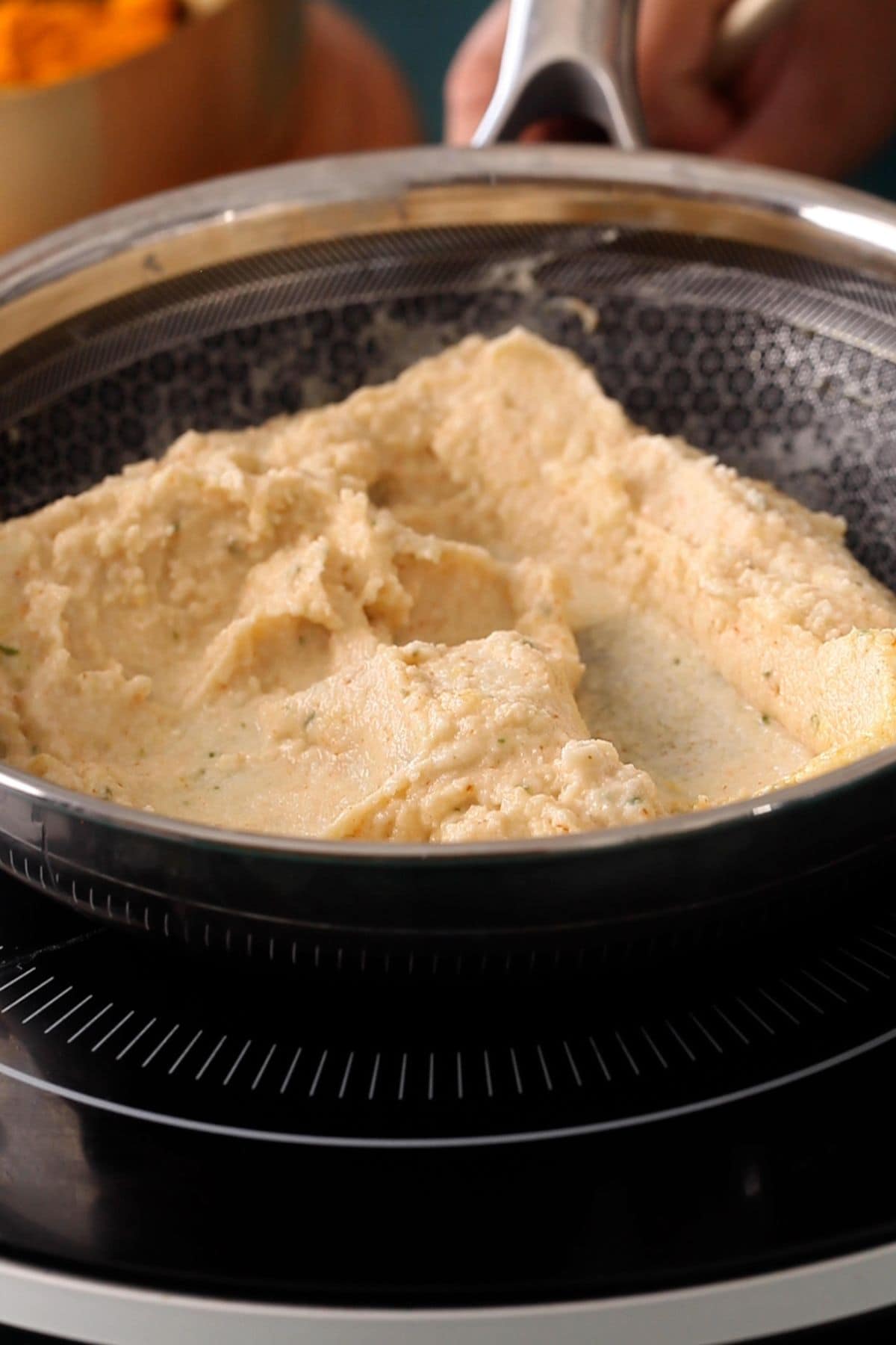 Cooking the ground lentils in a black pan.