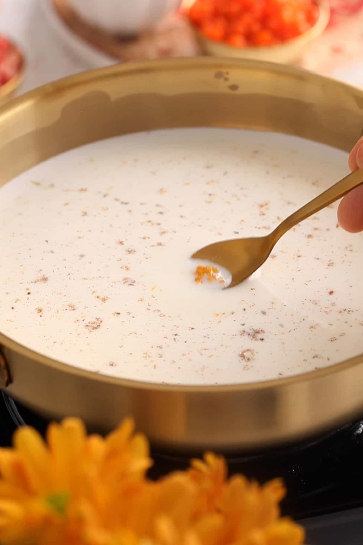 Orange zest and cardamom powder is added to milk.