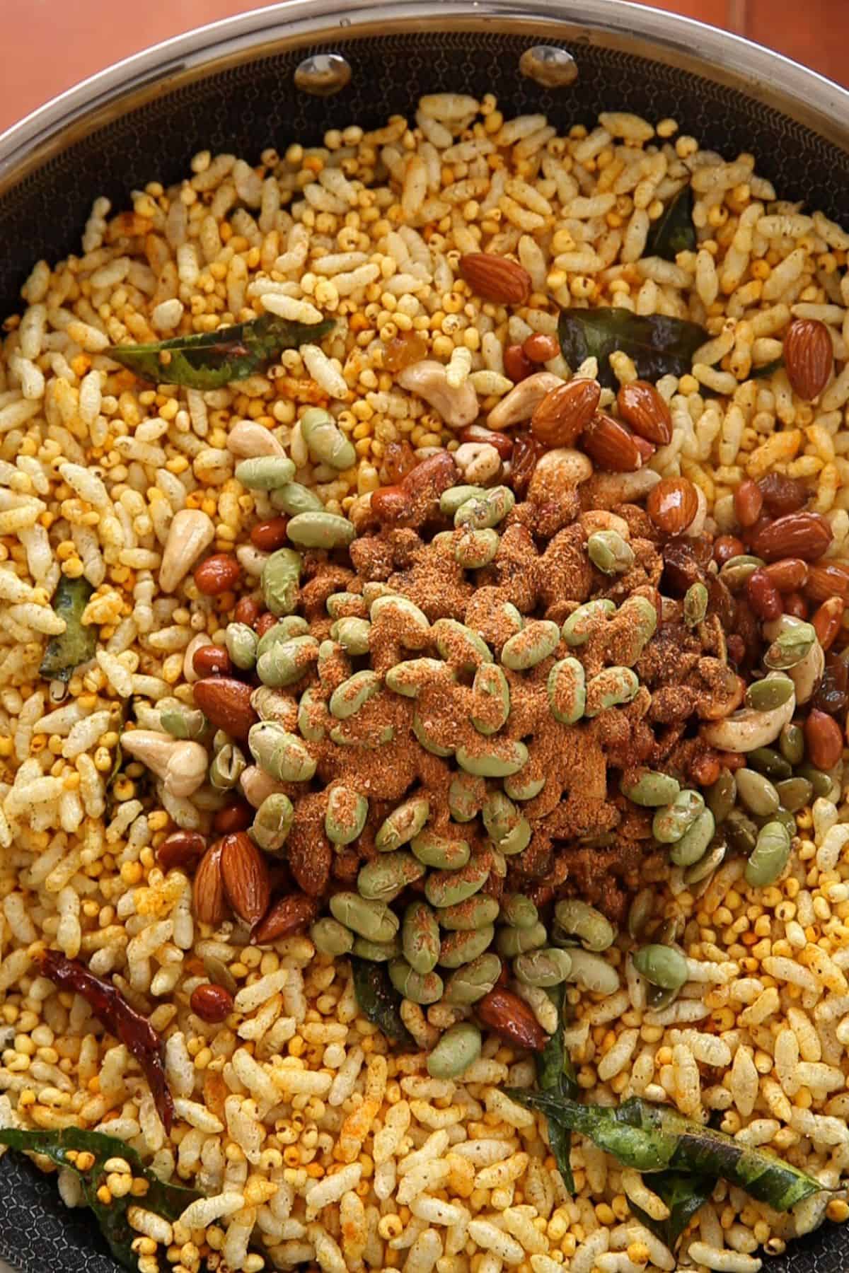 Nuts, seeds, spices and raisins are added to toasted murmura.