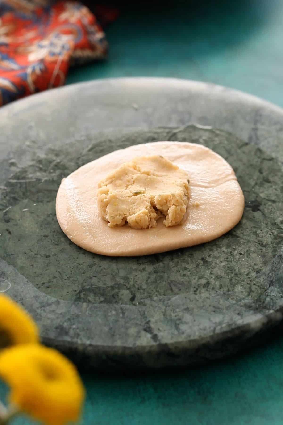 Dal filling is placed in the center of the rolled whole wheat dough.