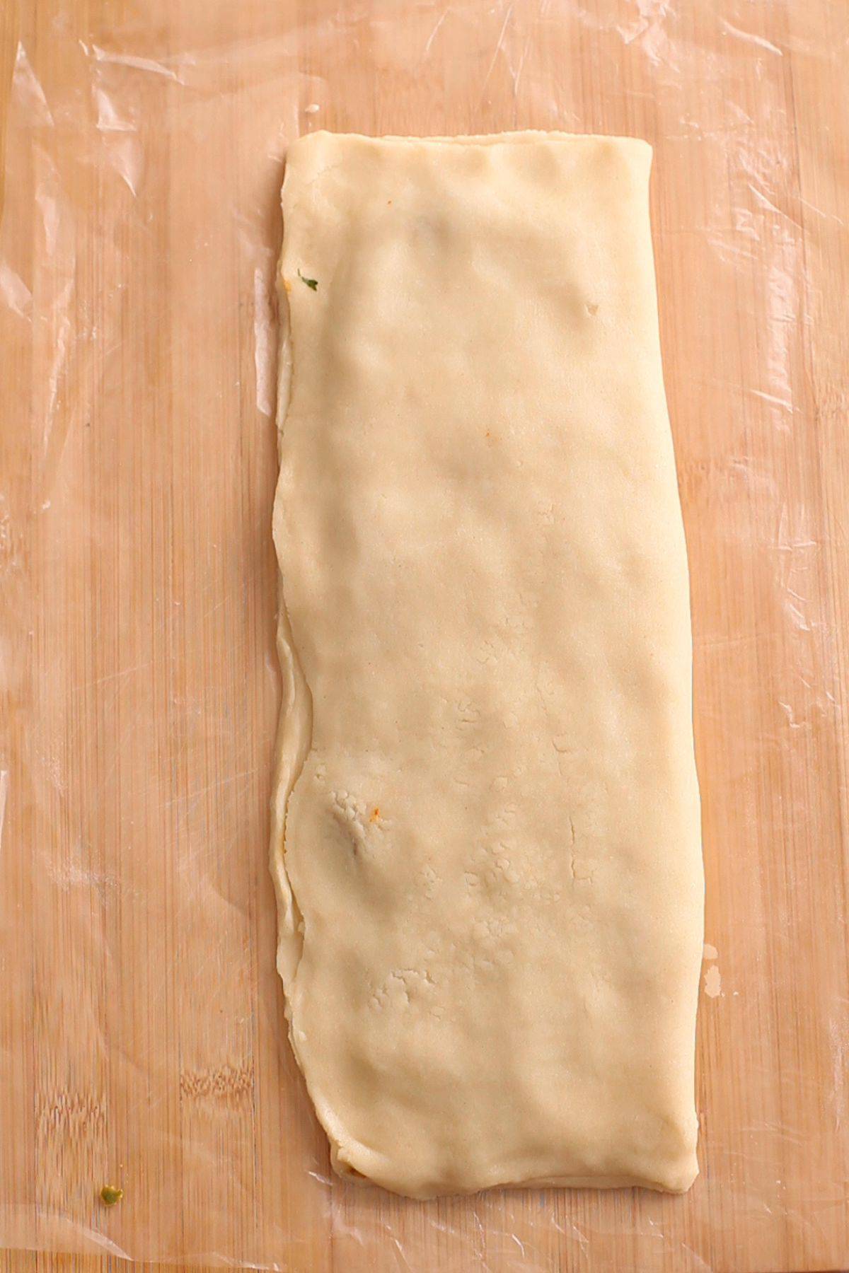 Other half is rolled over to enclose the potato filling and create a parcel.