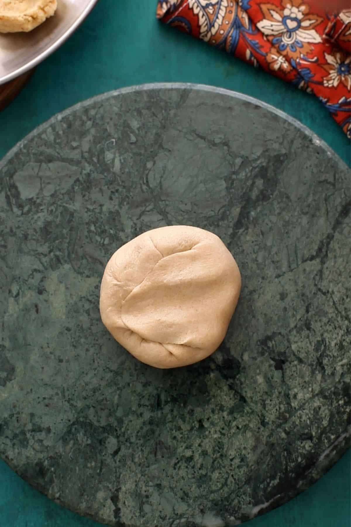 The edges of the dough are sealed to enclose the lentil filling.