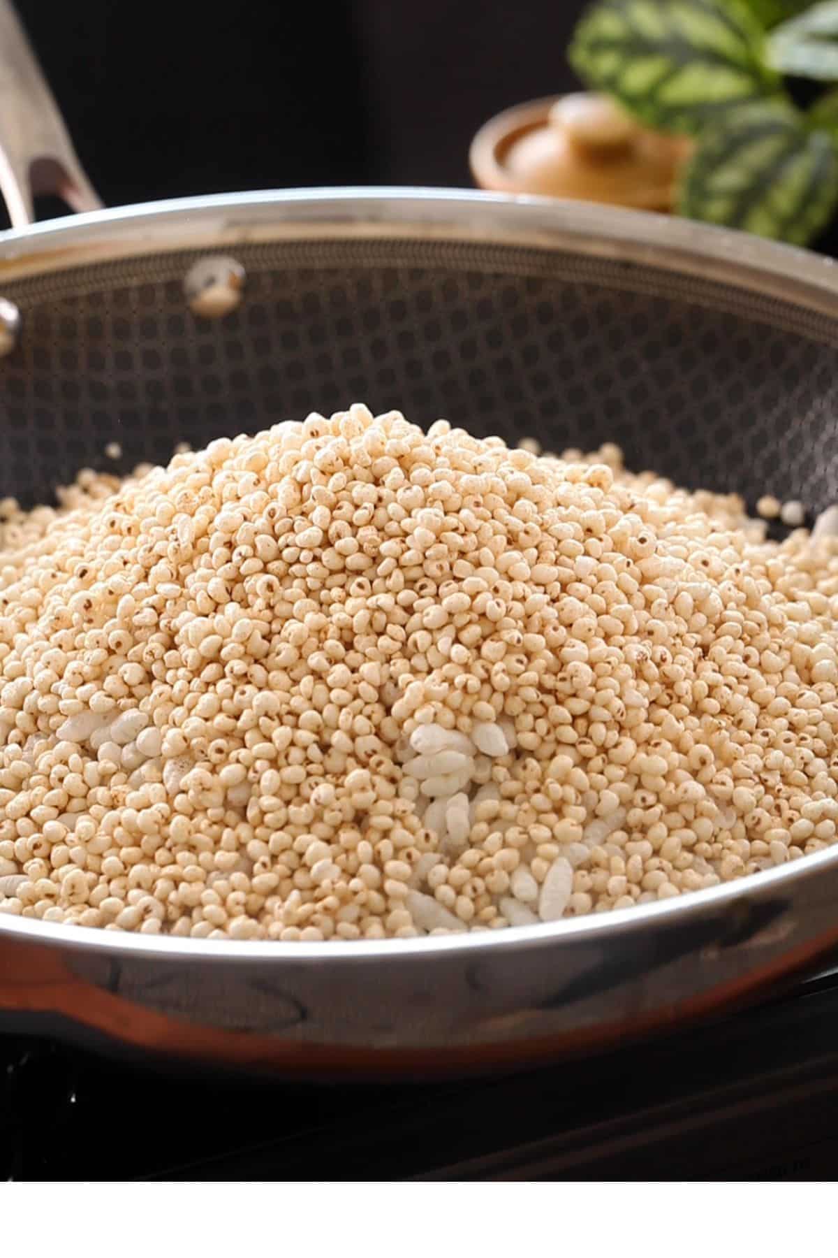 Adding puffed rice and millets to the spices.