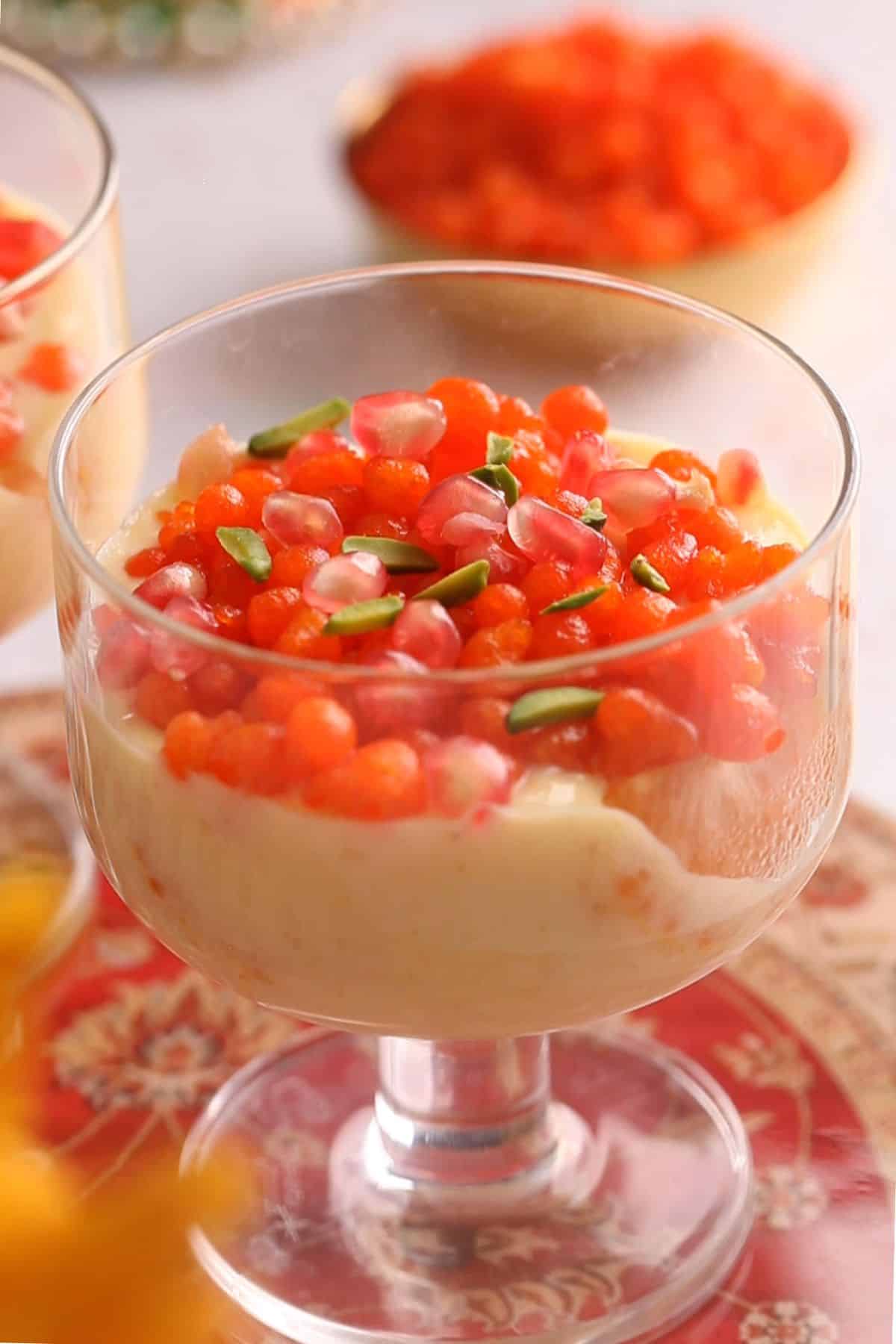 Pomegranate arils and silvered pistachios are added om top of boondi.