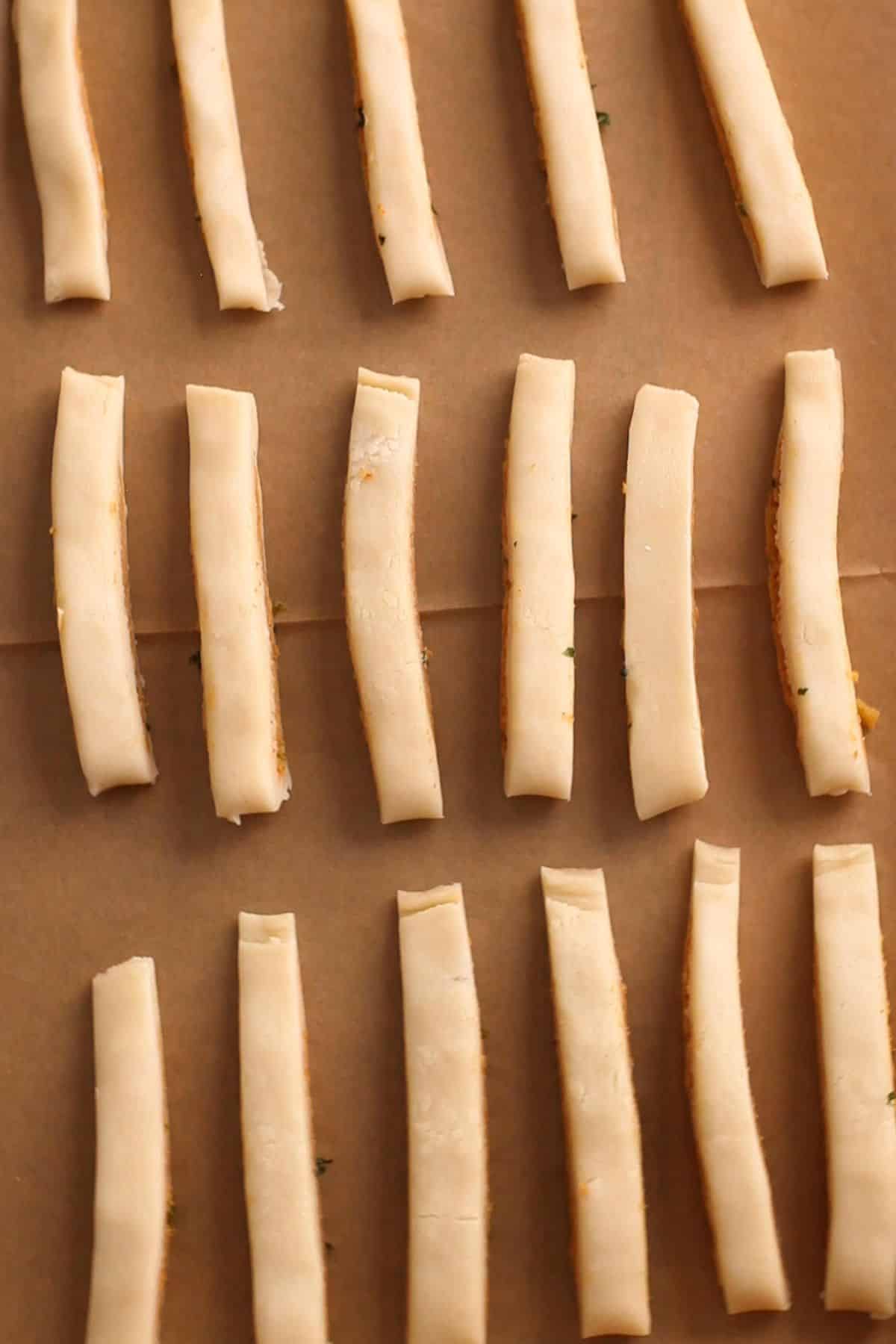 Samosa sticks placed on a baking sheet.
