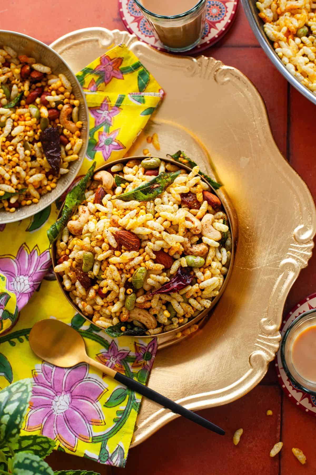 Overhead image of puffed rice chivda served in gold bowls.
