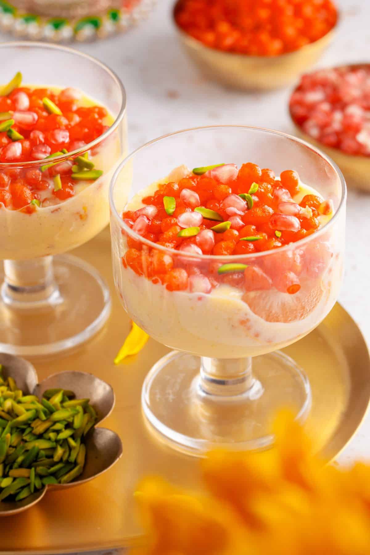 Sweet Boondi Custard Cups with orange slices and pistachios in glass dessert cups.