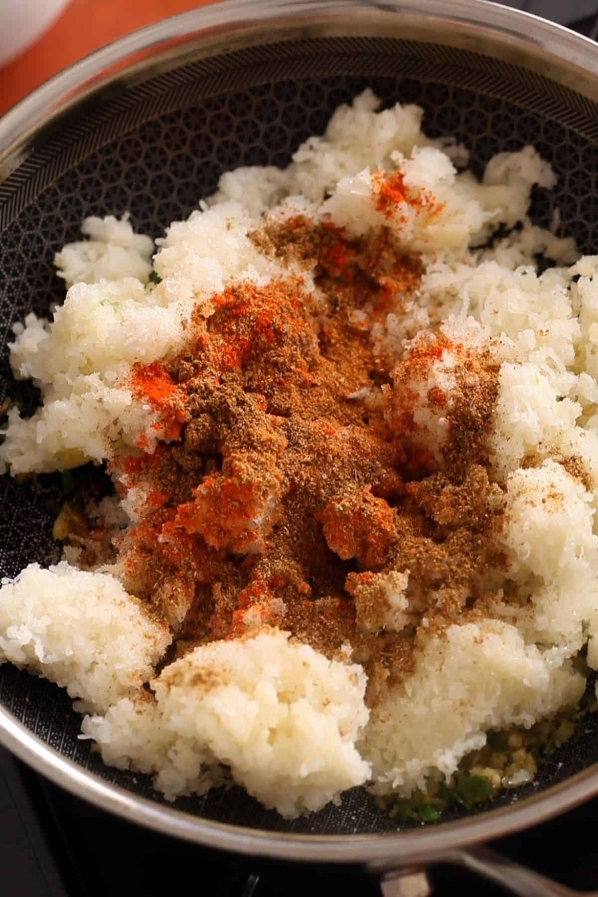 Fine grated potatoes are added along with all the ground spices.