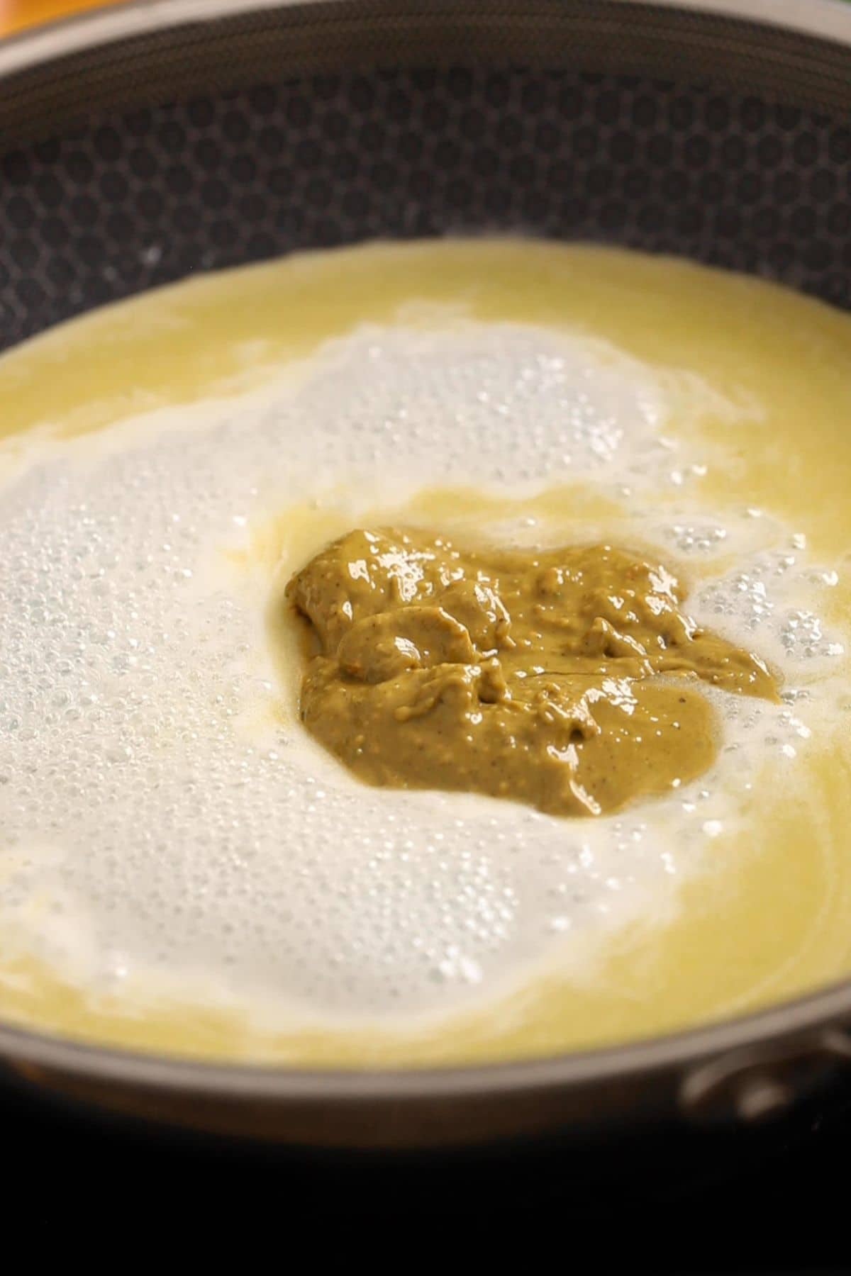 Unsweetened pistachio nut butter is added next to the pan.