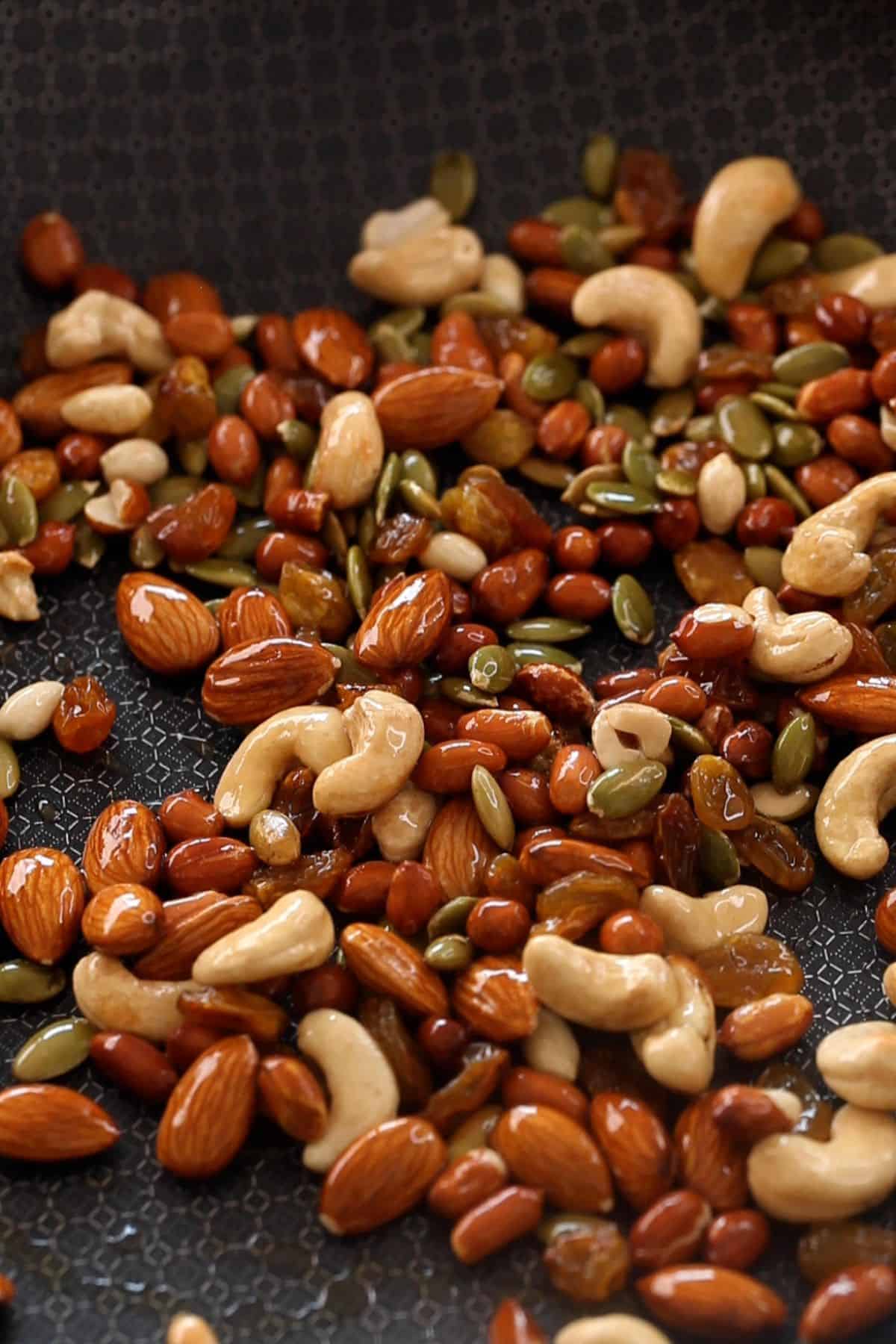 Roasted nuts in a black skillet for making chivda.