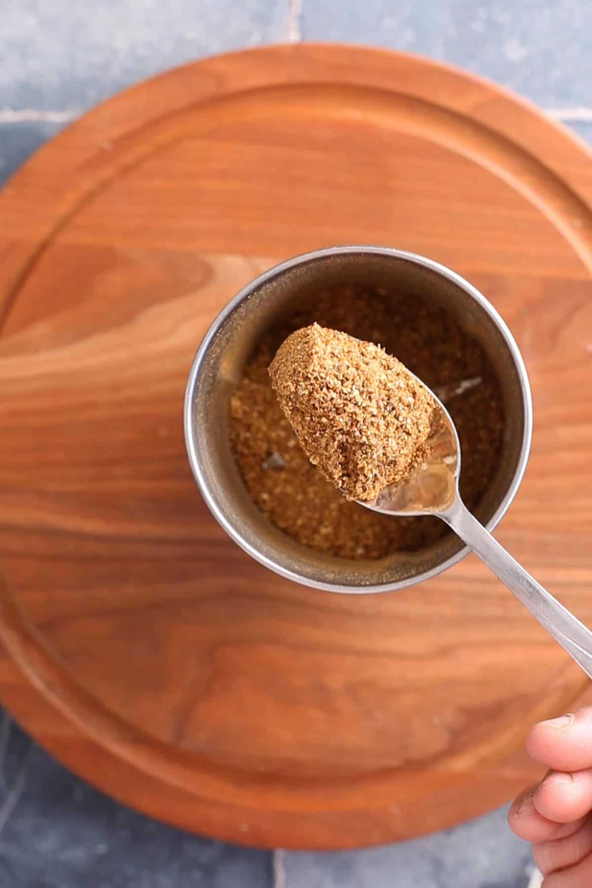 Homemade ground kadai masala in a spoon.