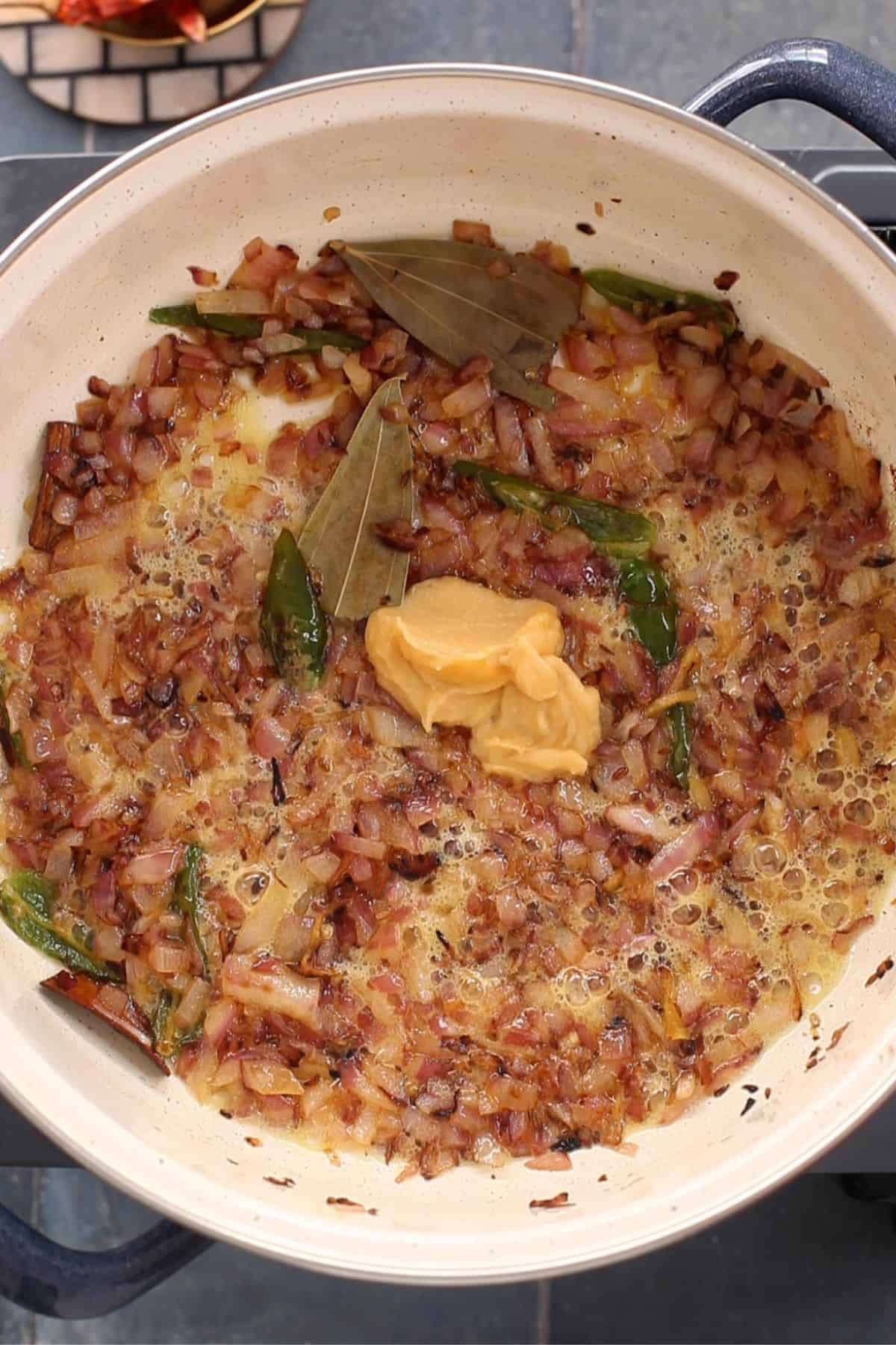 Browned onions and garlic paste in cooking pot.