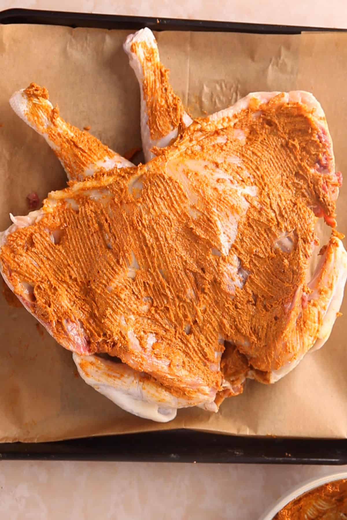 Picture showing that the underside of chicken has been rubbed with masala butter.