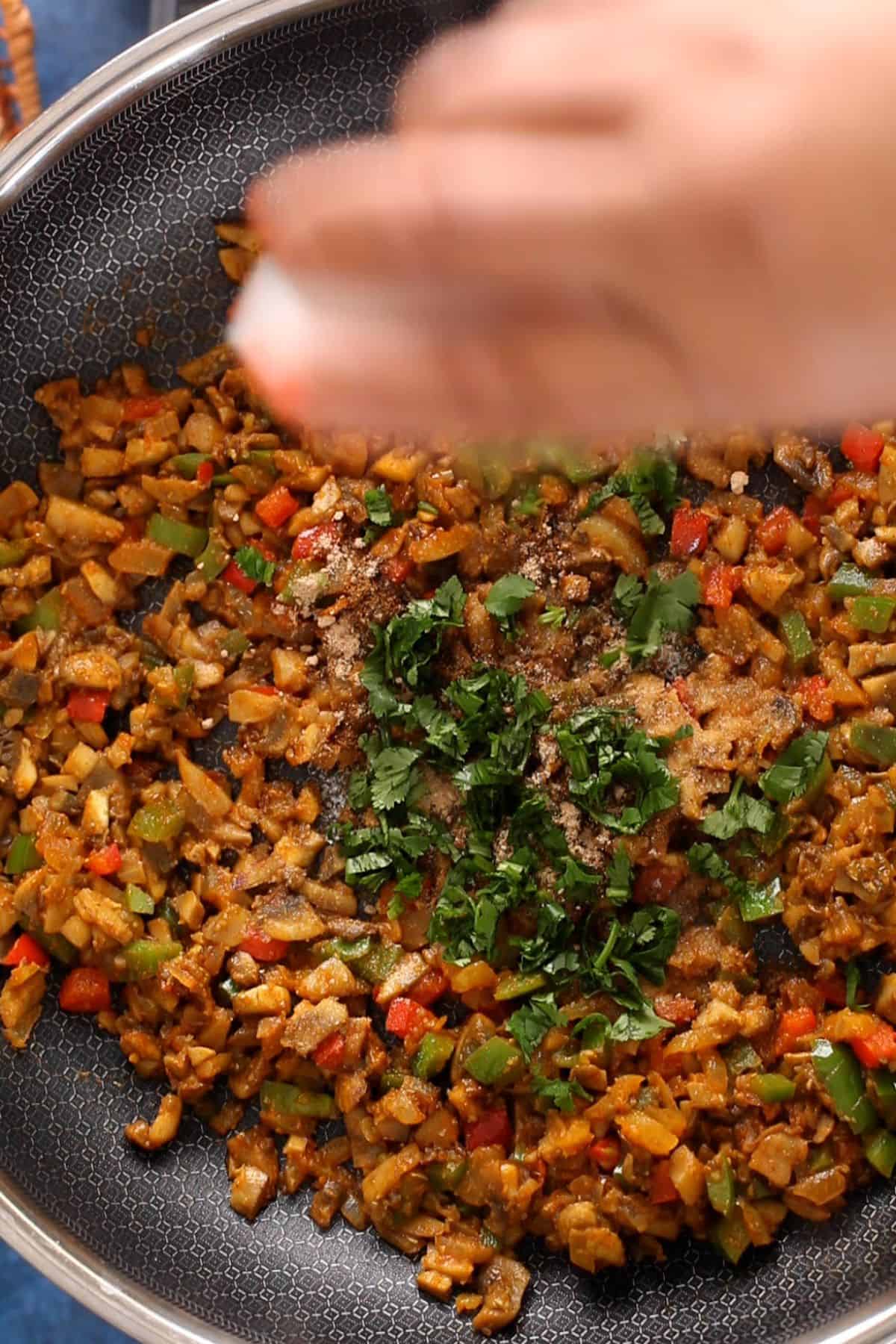 Mushroom masala is finished with spices and chopped cilantro.