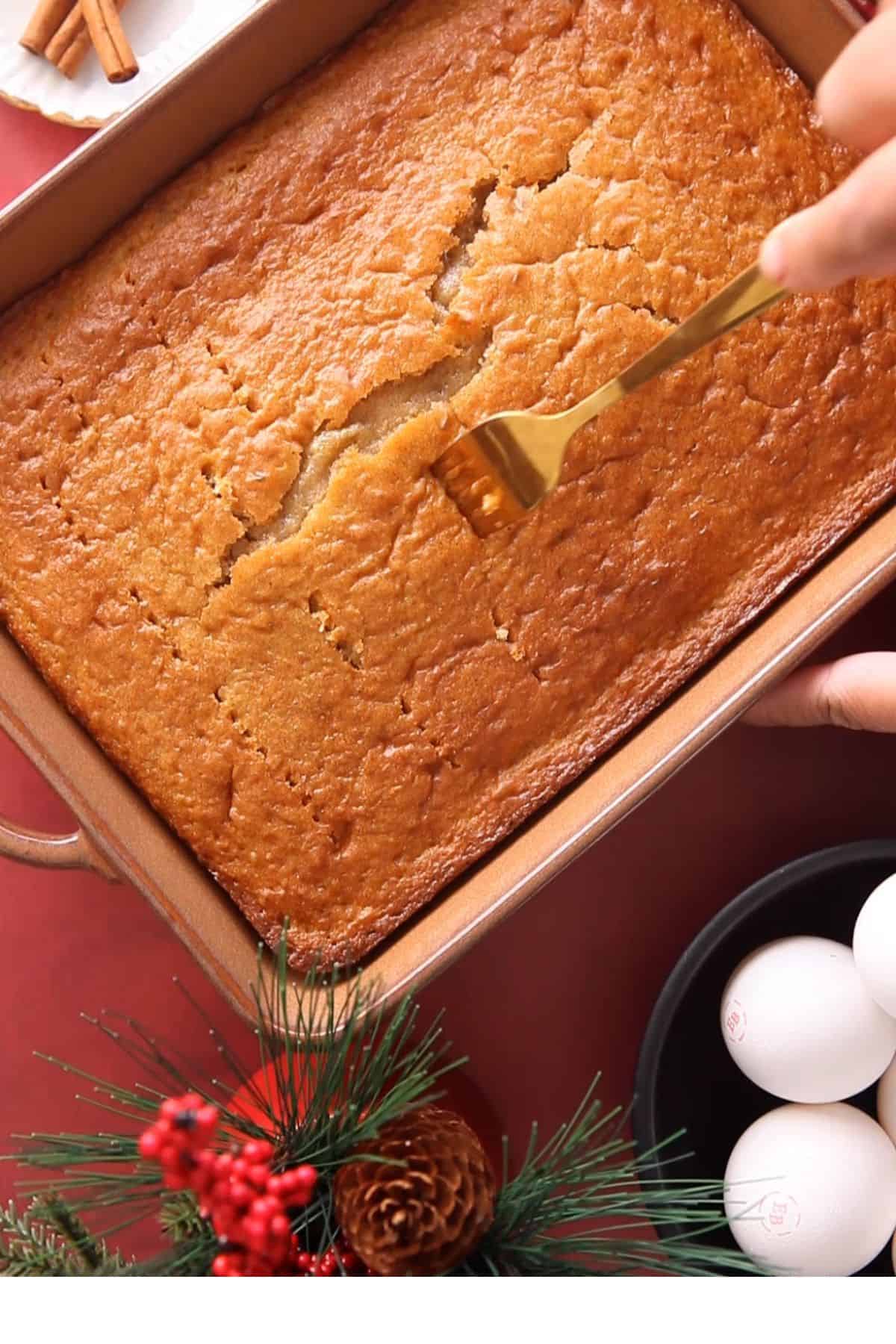 Holes are poked in the baked cake sponge using a fork.