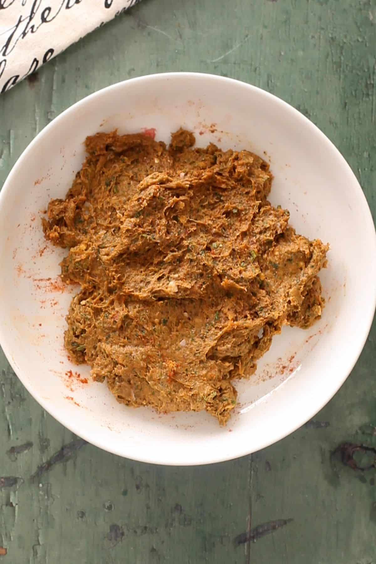 Ground seek kebab mixture in a white plate.