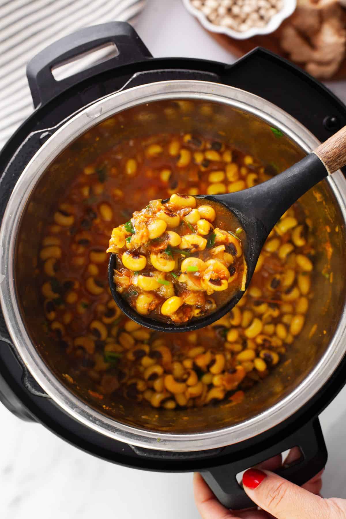 Lobia masala in a black serving spoon over instant pot insert. 