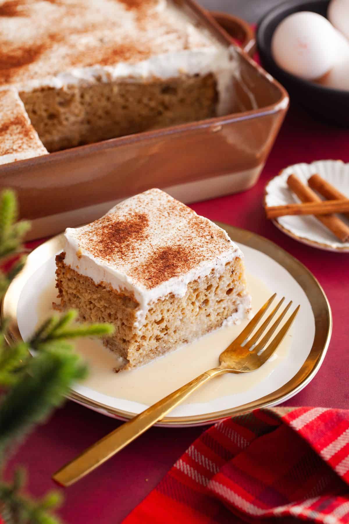 Gingerbread tres leches slice served on a gold and white plate.