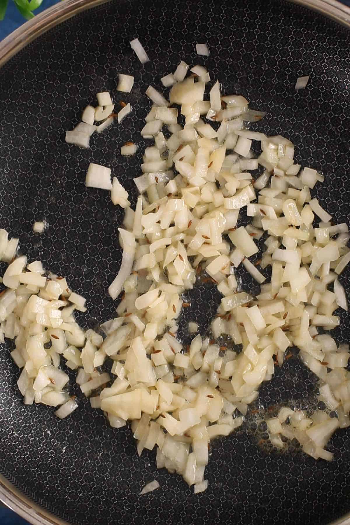 Sauteed onion in a black pan.