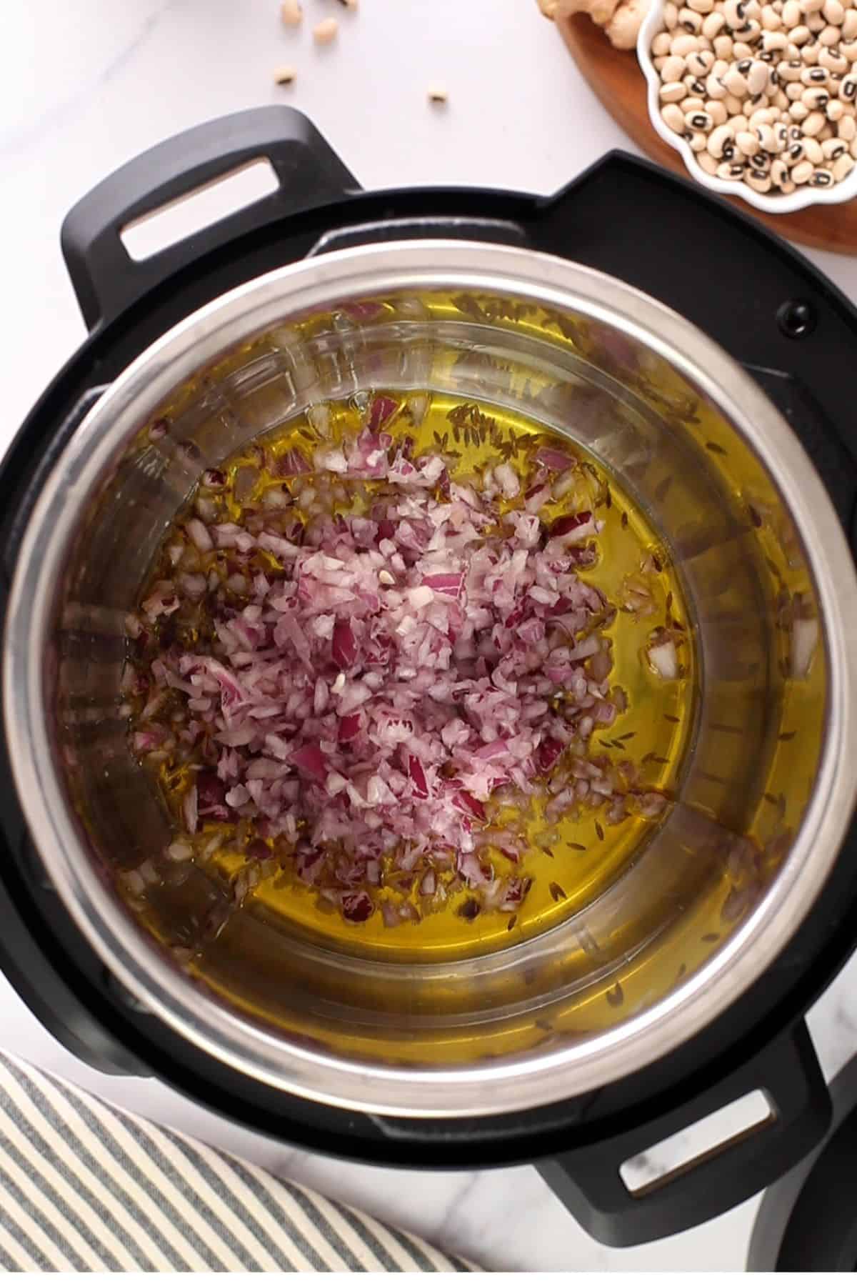 Onion is added to instant pot.