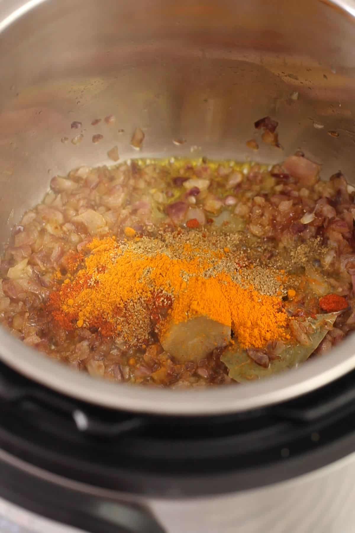 Ginger garlic and ground spices are added to browned onions. 