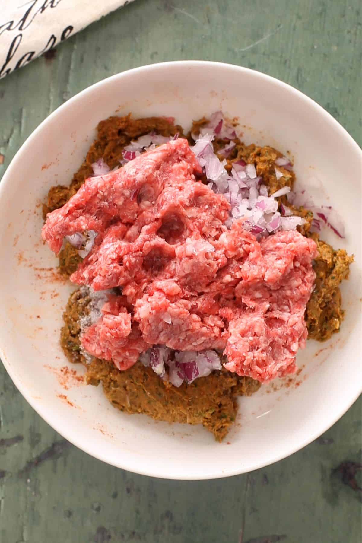 Lamb mince is added to the ground seekh kebab mixture. 