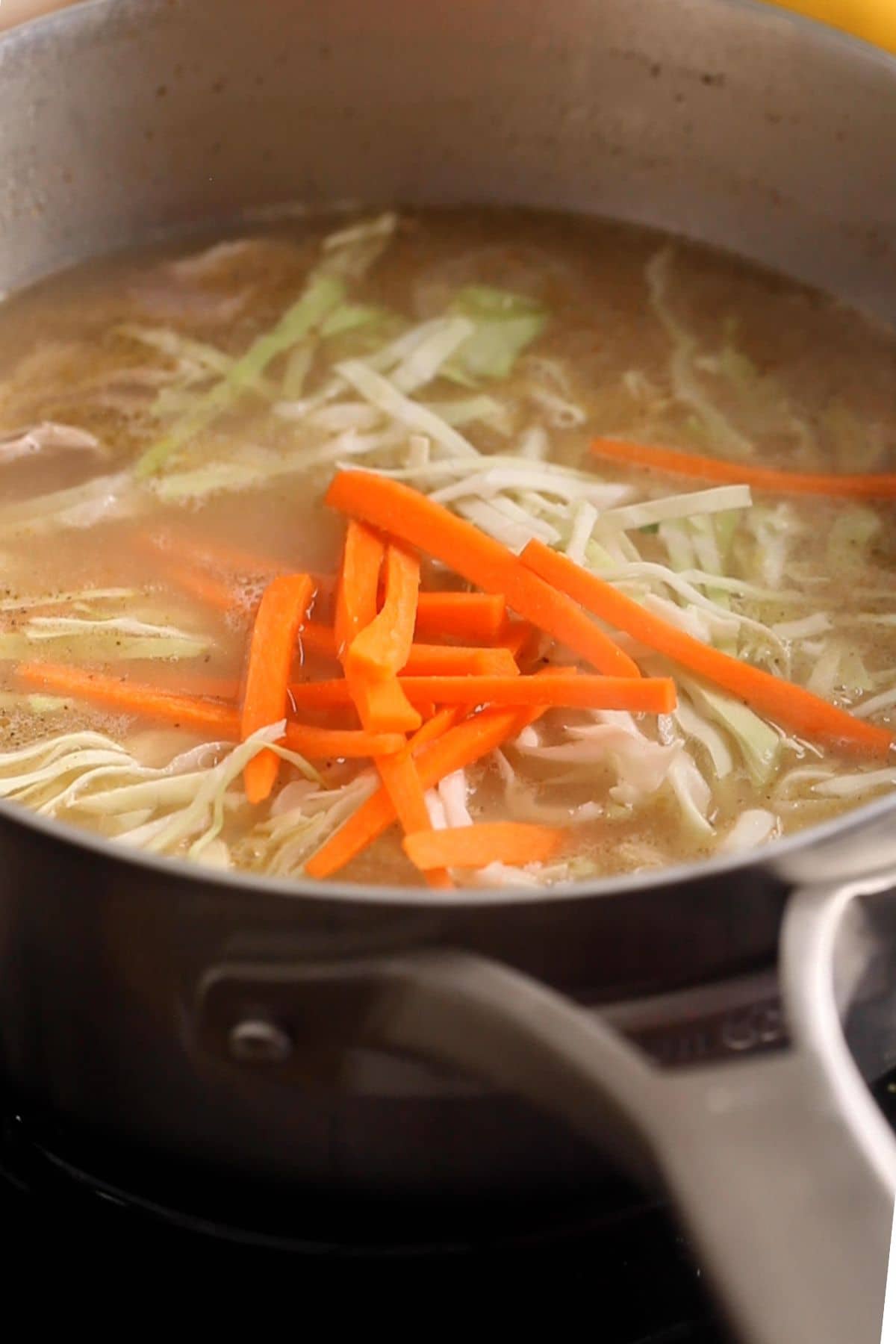 Vegetables are added to the chicken soup.