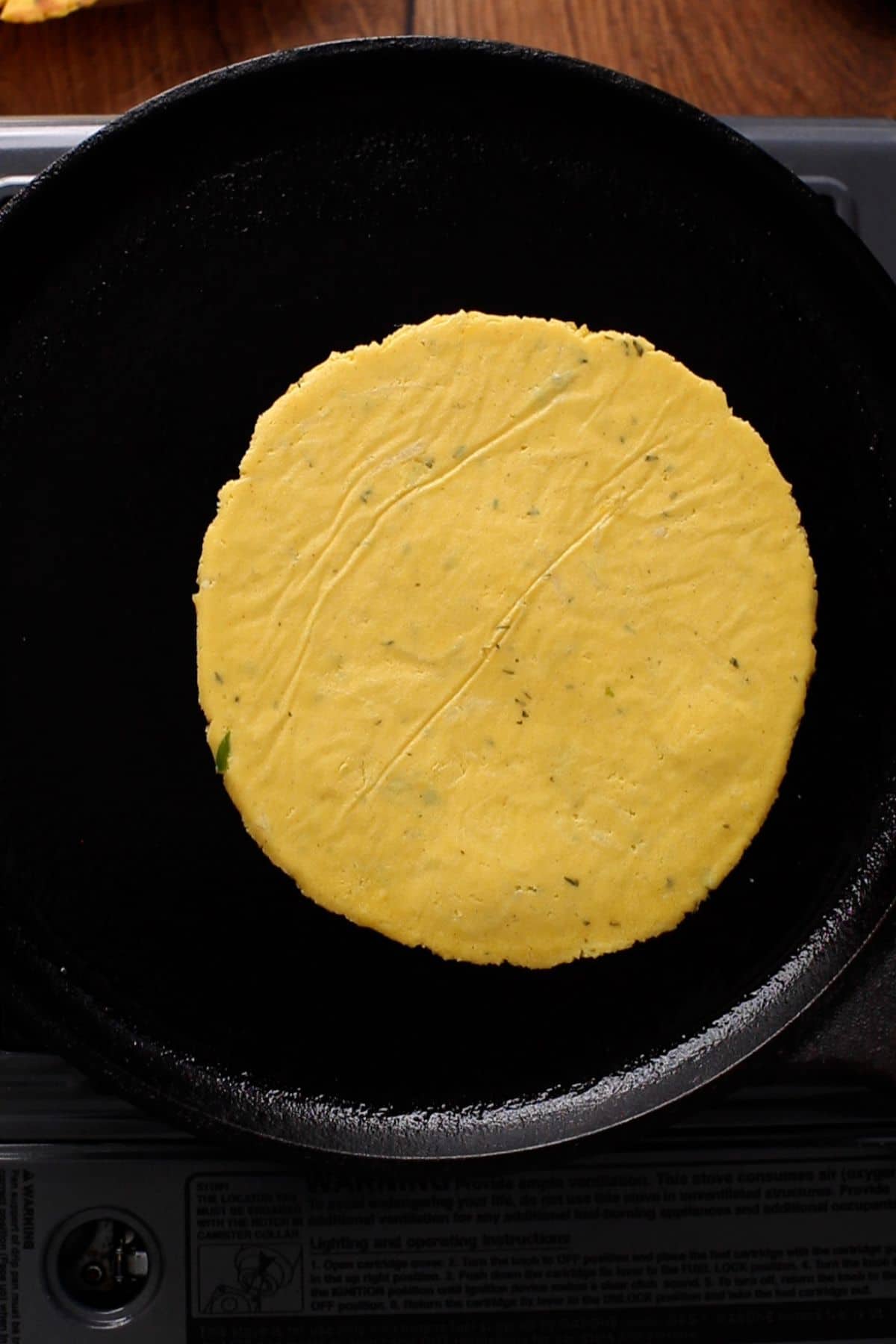 Cooking makki ki roti on iron griddle.