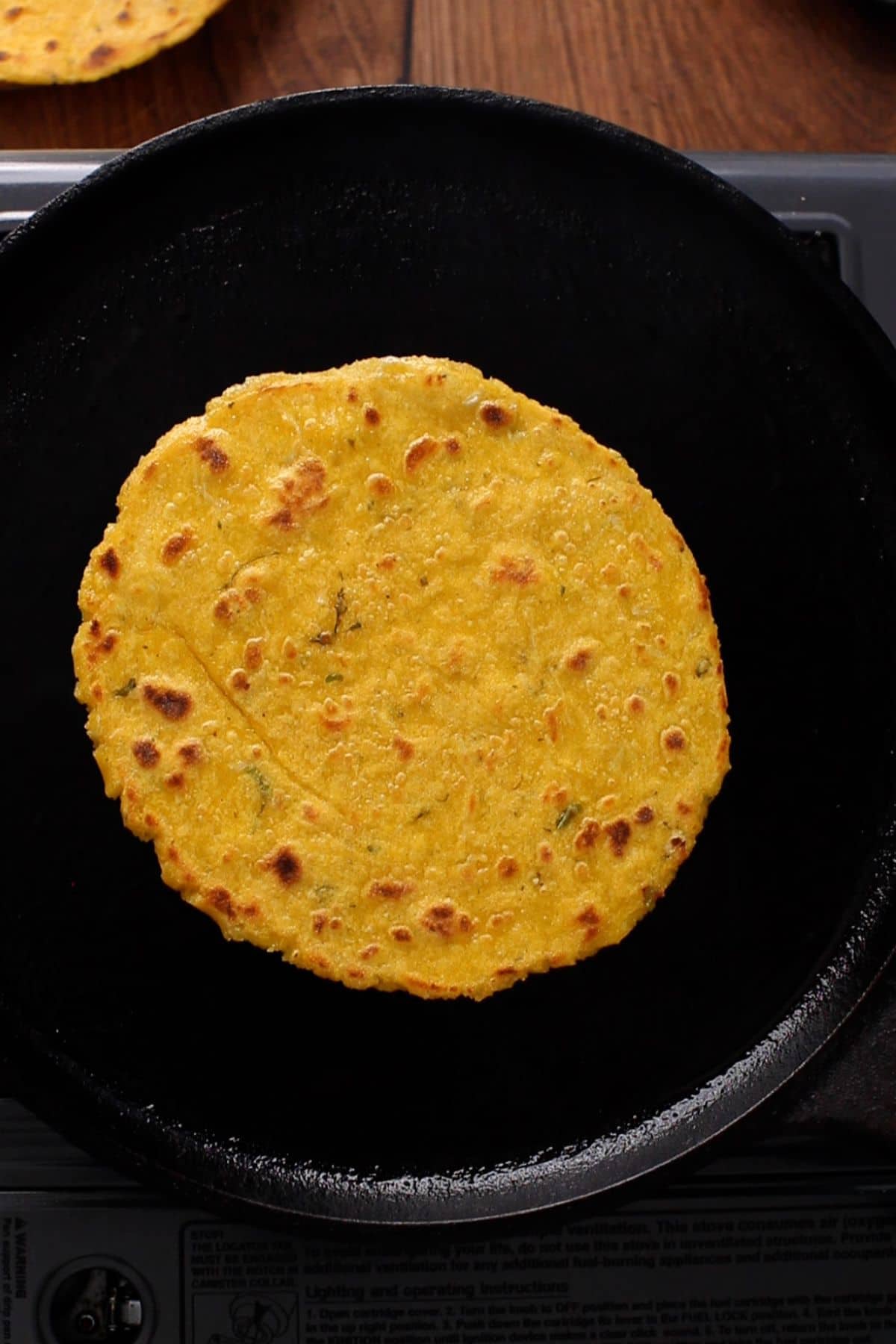 Makki ki roti is cooked to golden brown with charred spots.
