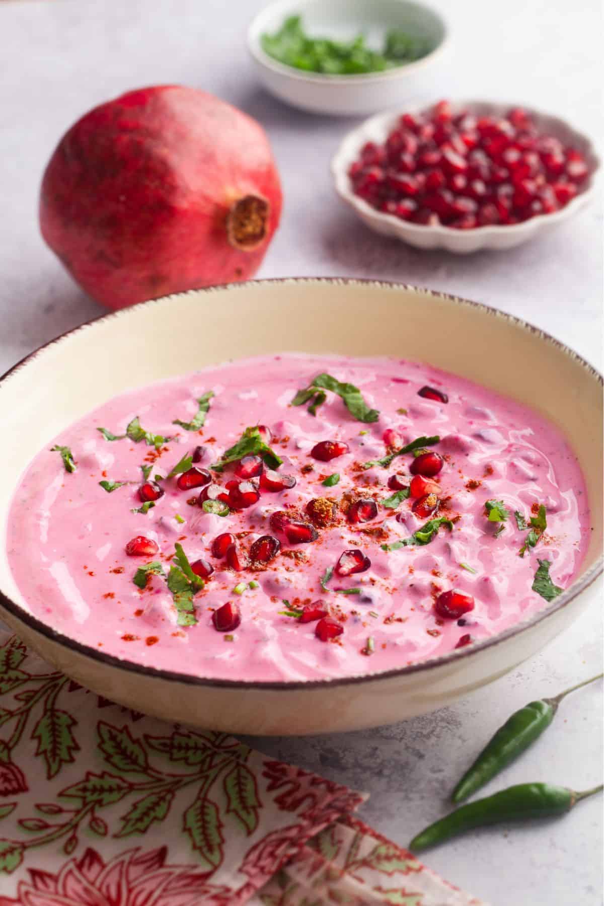Pomegranate Yogurt Raita served in a beige bowl.