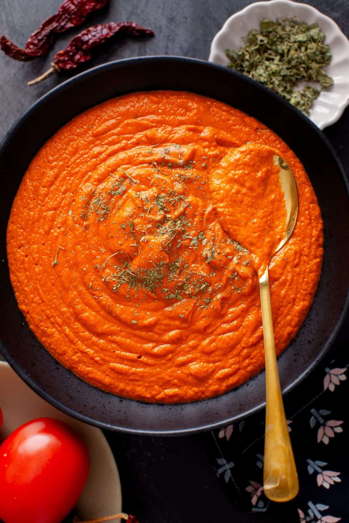 Makhani Sauce in a black bowl with a gold spoon. 
