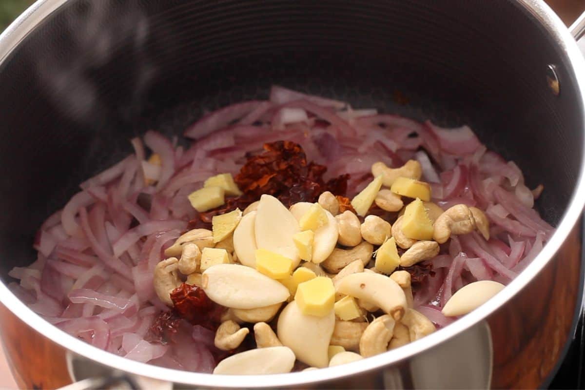 Ginger garlic, cashews and chili are added to cooking pot.