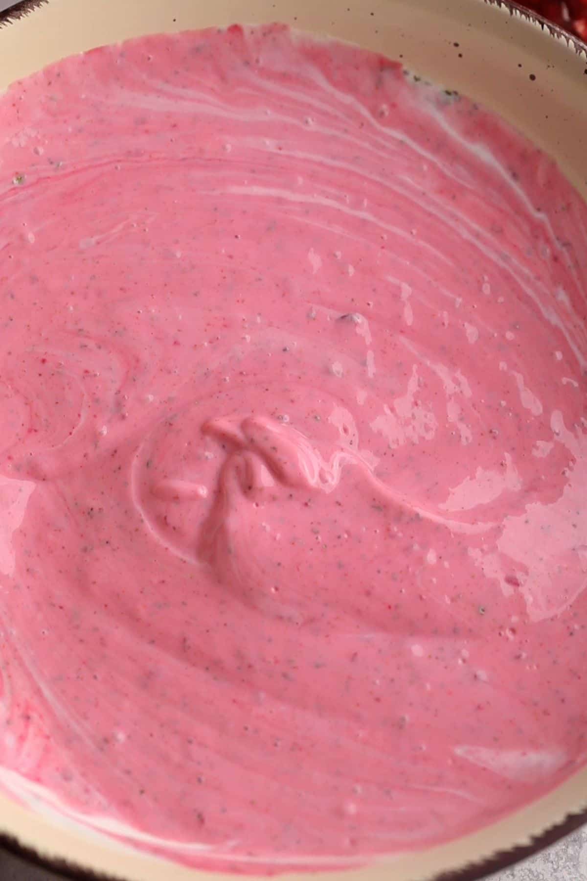 Spices and beet paste are mixed with yogurt. 