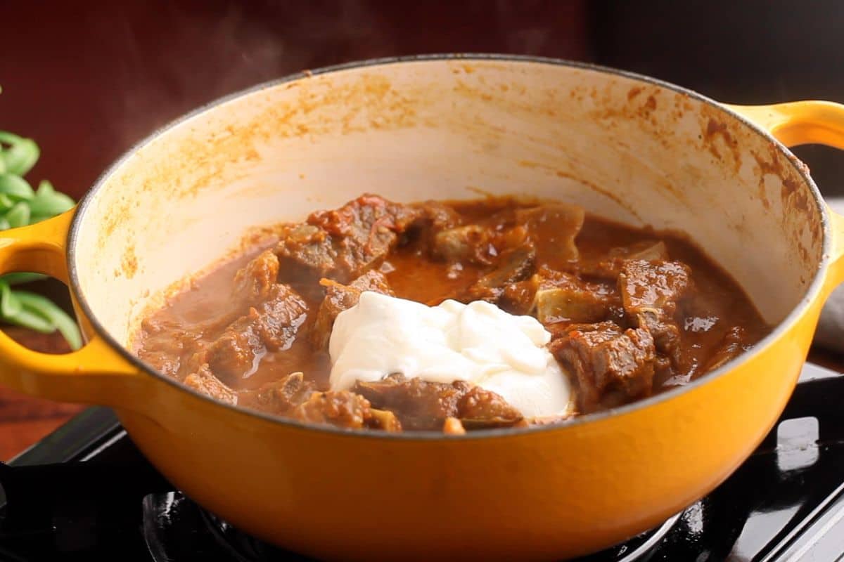 Whisked yogurt is added next to the goat meat.