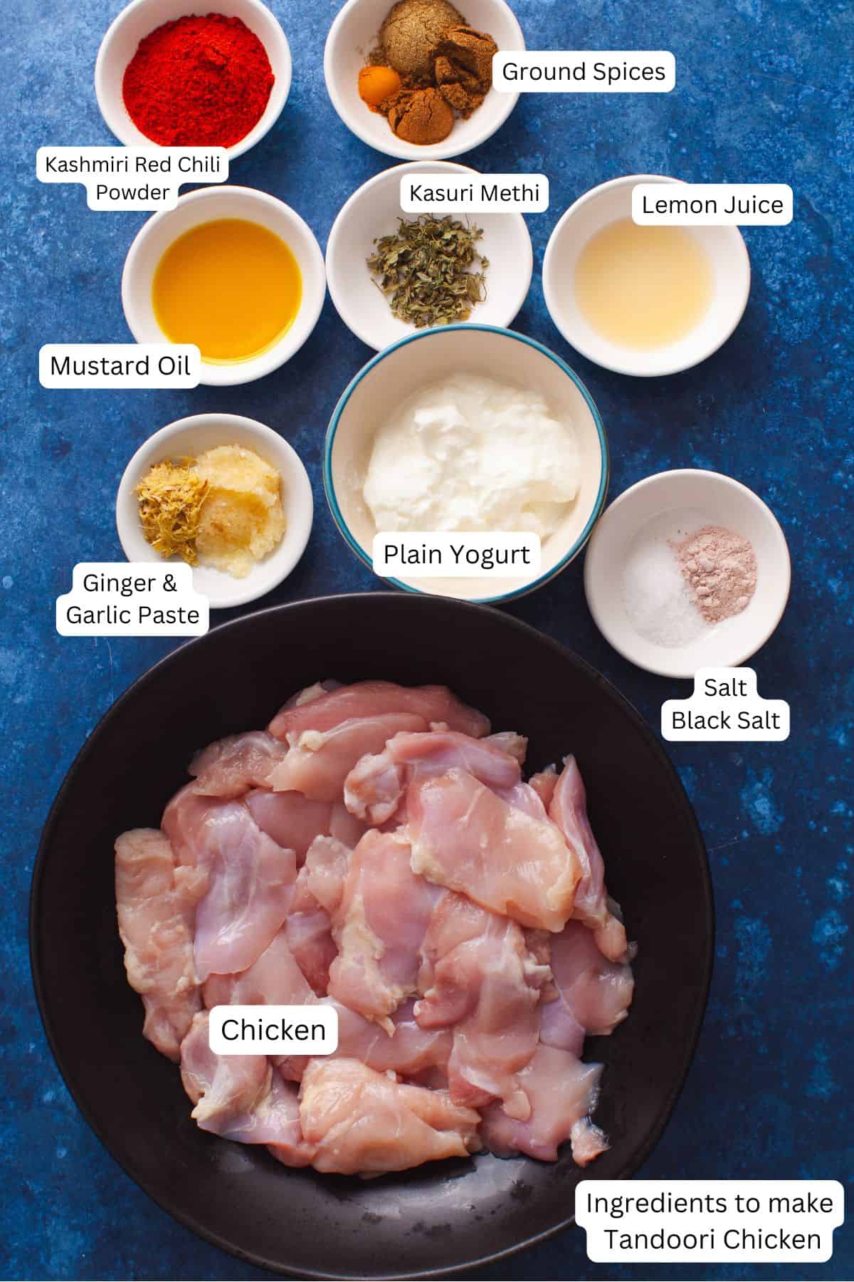 Various ingredients for making Tandoori Chicken displayed on a blue surface.