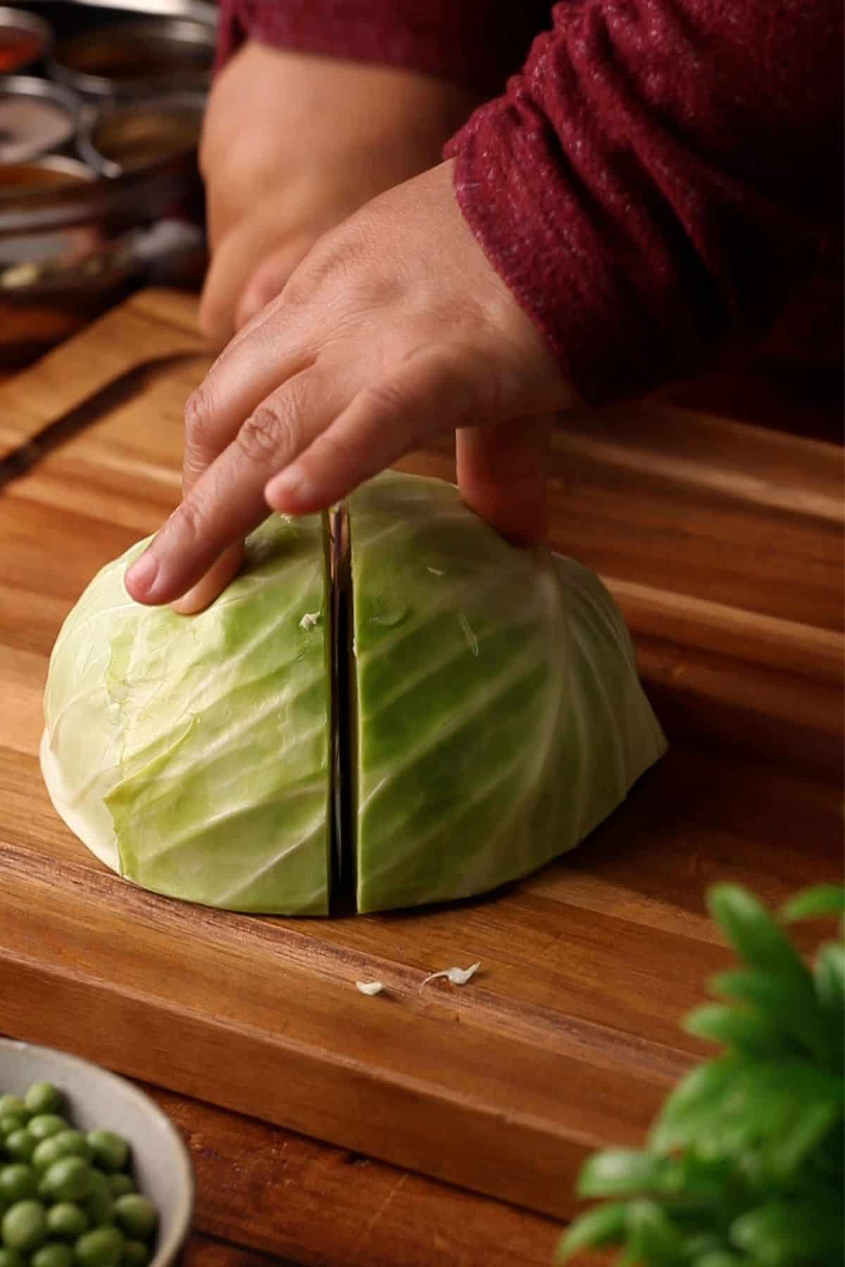 Cutting a half of cabbage into smaller sections.