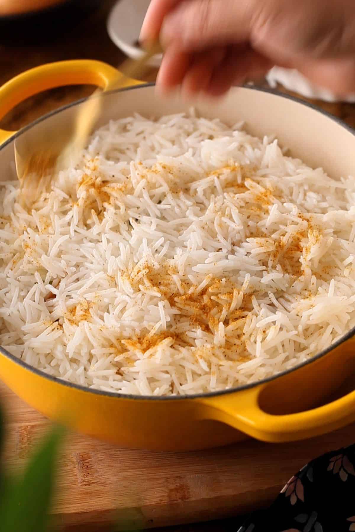 Biryani masala powder is sprinkled over layer of rice.