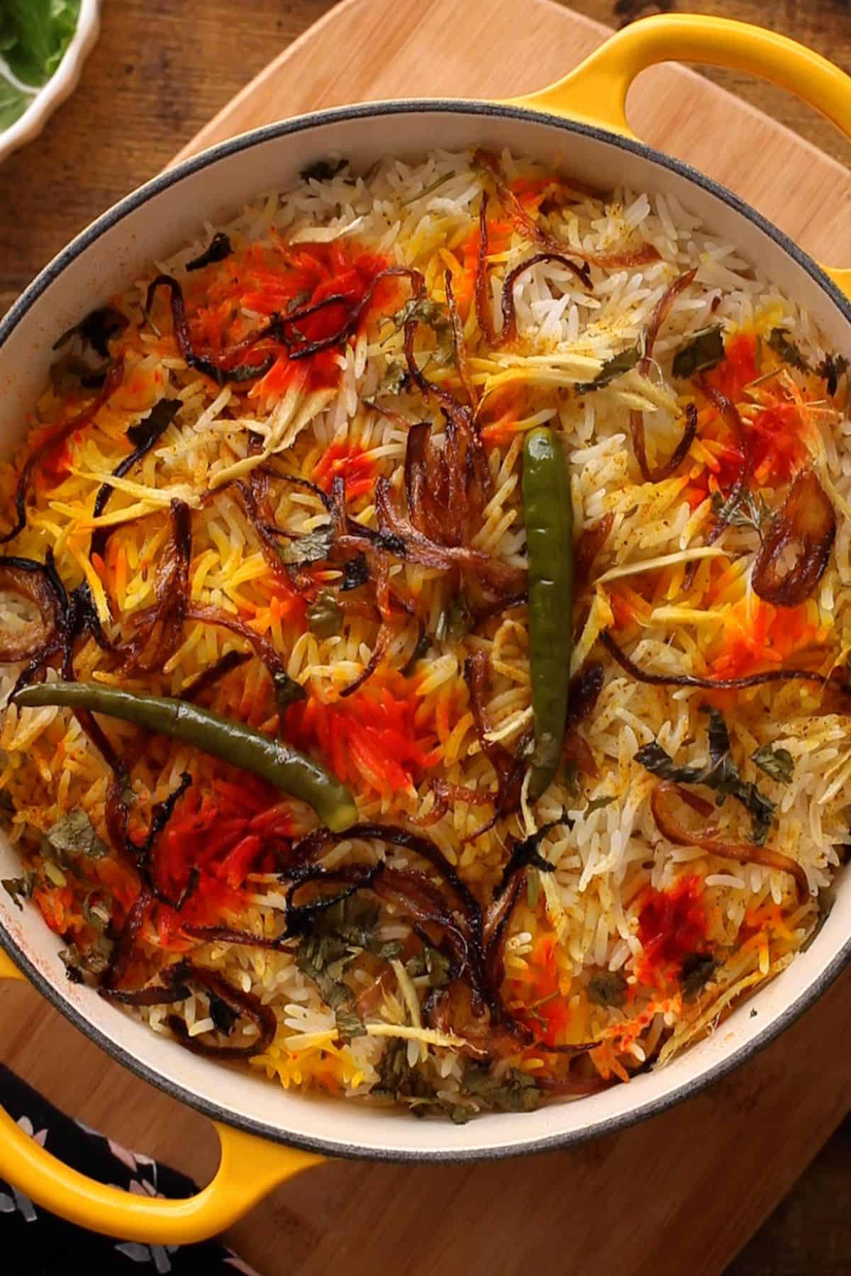 A pot of colorful dum cooked egg biryani.
