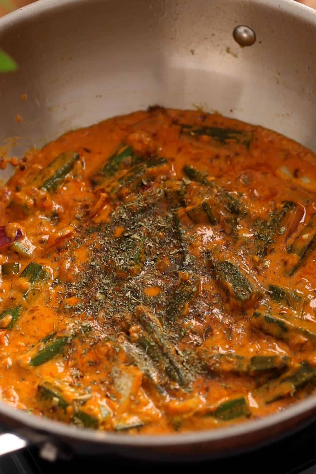 Bhindi masala is finished with spices and dried herb.