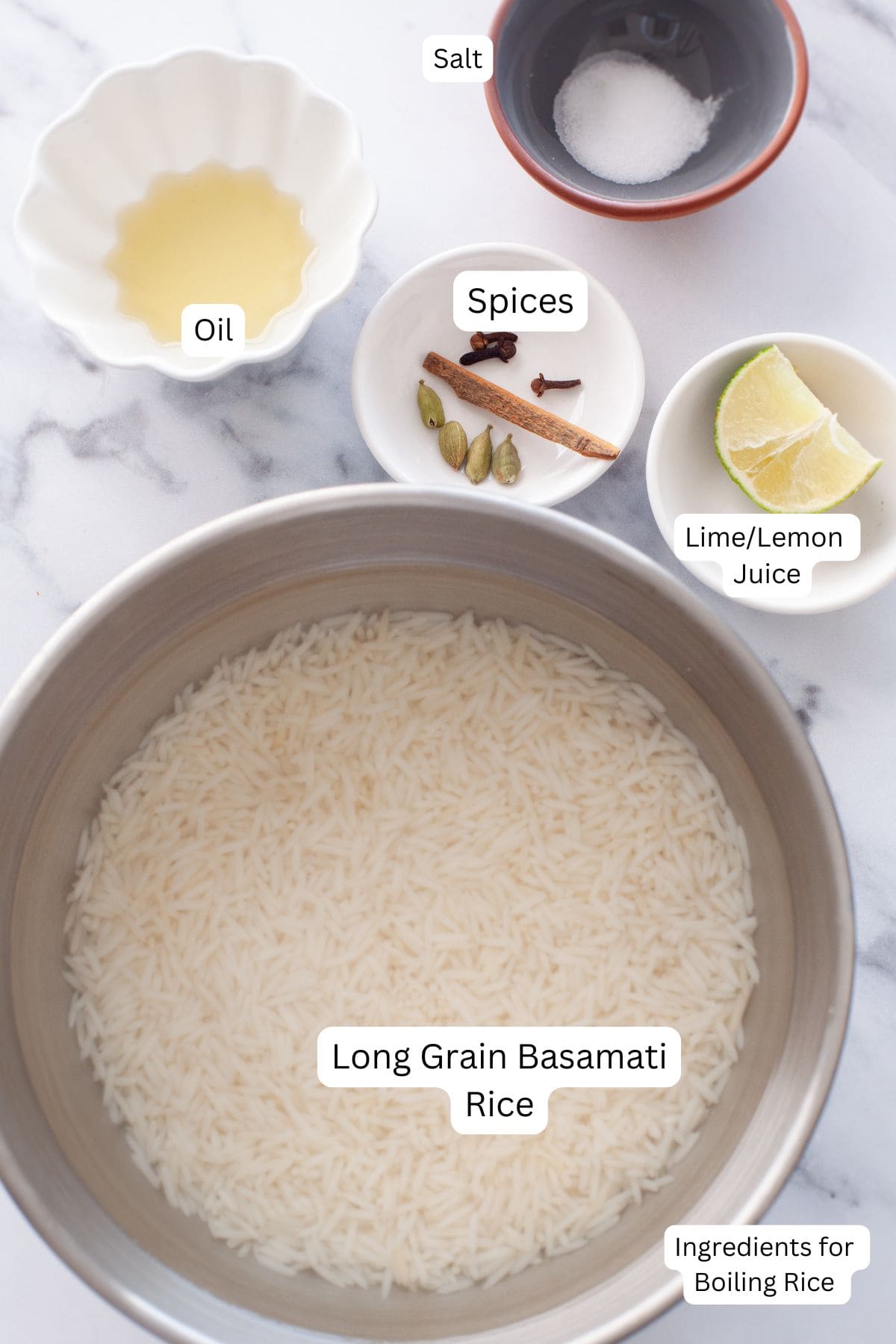 Ingredients needed to boil basmati rice placed on a white marble board.
