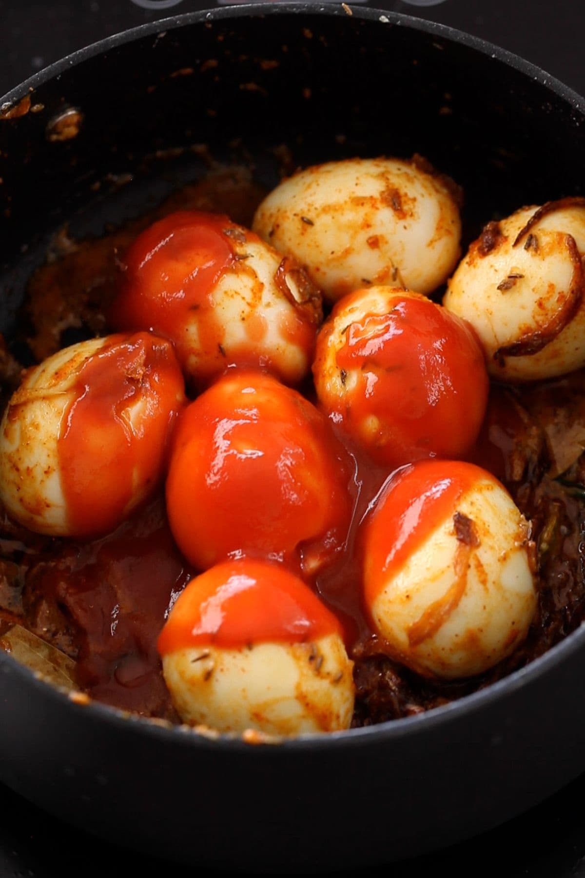 Tomato sauce is added to egg masala. 