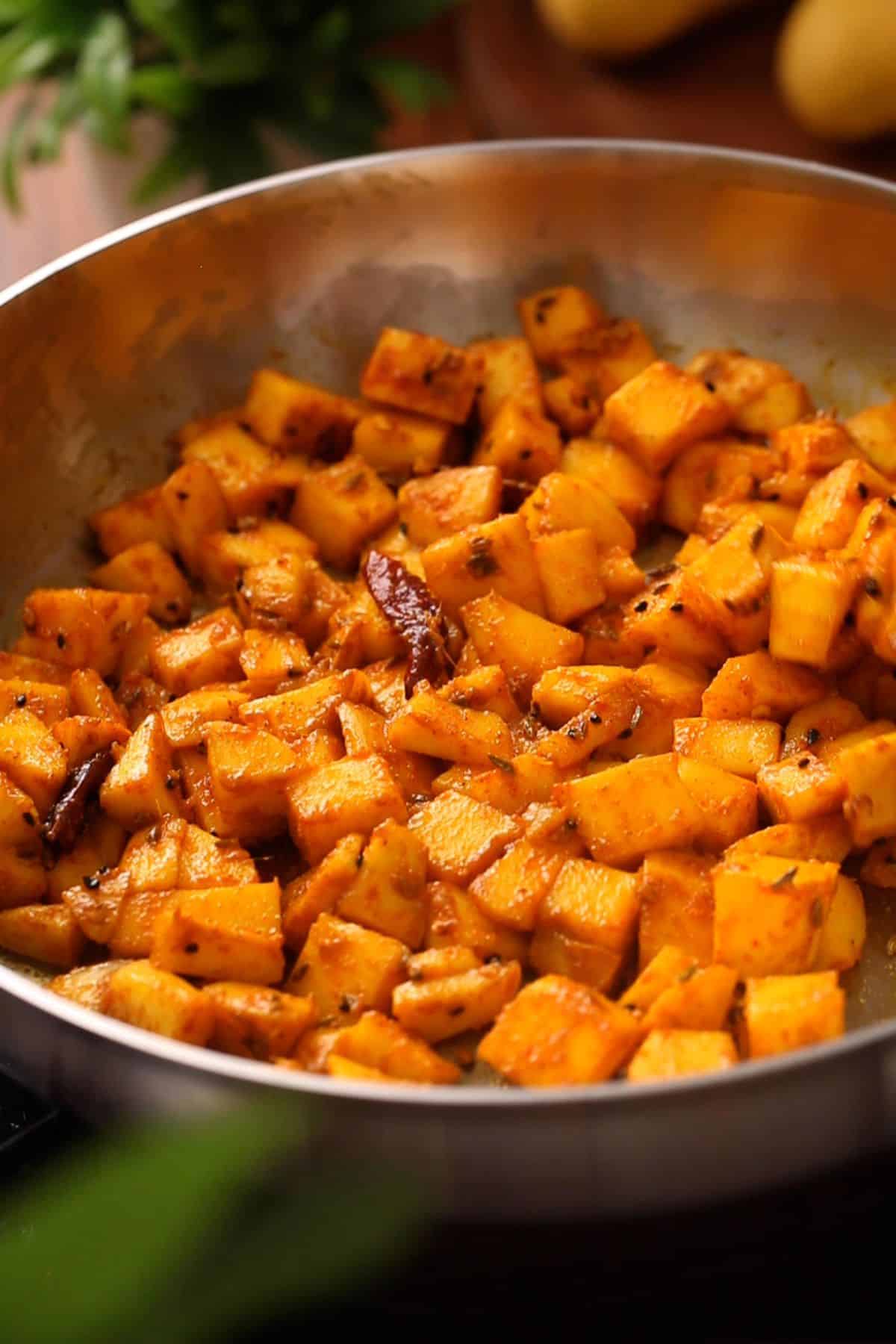 A pan filled with golden-spiced mango cubes.